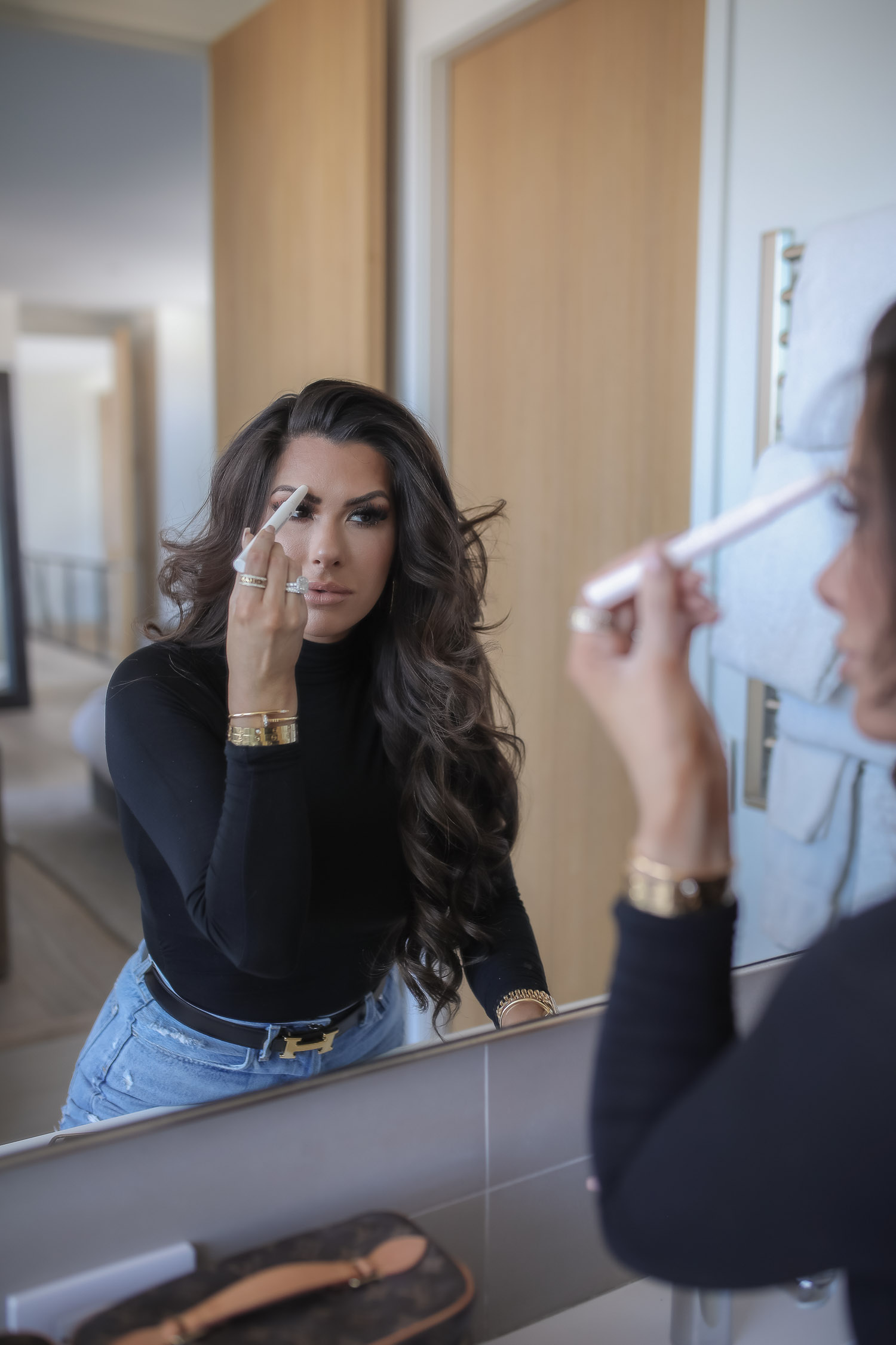 Sephora savings event fall 2020, sephora VIB sale event, beauty blogger sephora favorites fall 2020, emily ann gemma-10 |Sephora Beauty Insider Sale by popular US beauty blog, The Sweetest Thing: image of Emily Gemma wearing a black turtle neck and distressed jeans and applying makeup in a bathroom mirror.