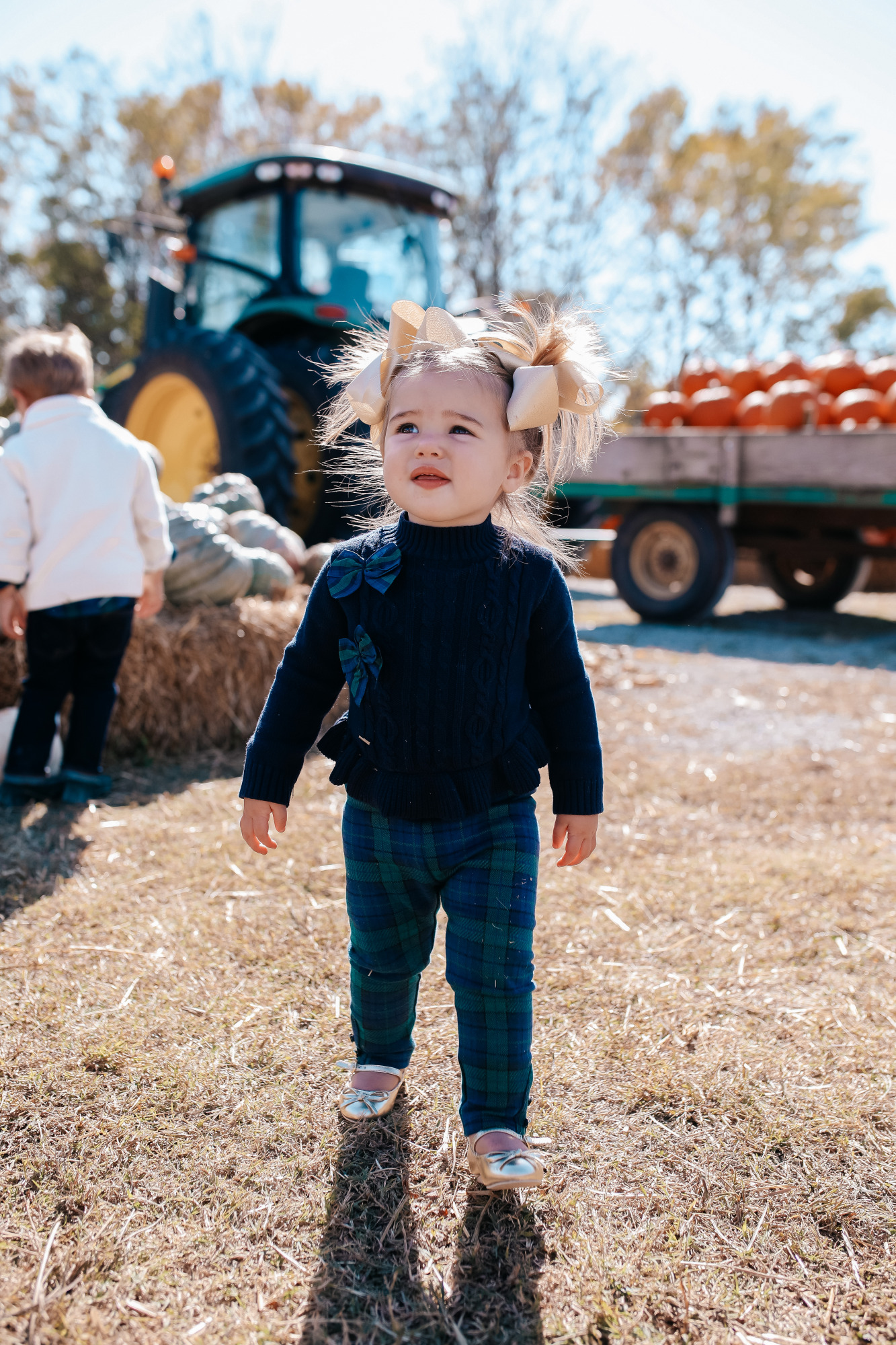 janie and jack kids clothing fall 2020, kids fall fashion 2020, the sweetest thing blog17 |janie and jack kids clothing fall 2020, kids fall fashion 2020, the sweetest thing blog17 | Janie and Jack Kids Clothing by popular US fashion blog, The Sweetest Thing: image of two kids sitting next to a pile of pumpkins and wearing a Janie and Jack PLAID POPLIN SHIRT, Janie and Jack SHAWL COLLAR PULLOVER, Janie and Jack SLIM SELVEDGE JEAN IN MOONLIGHT INDIGO WASH, Janie and Jack LEATHER TRIM BELT, Janie and Jack ARGYLE SOCK, Janie and Jack SUEDE DRIVING SHOE, Janie and Jack PEPLUM BOW SWEATER, Janie and Jack PLAID PONTE BUTTON CUFF PANT, and Janie and Jack METALLIC BOW FLAT.