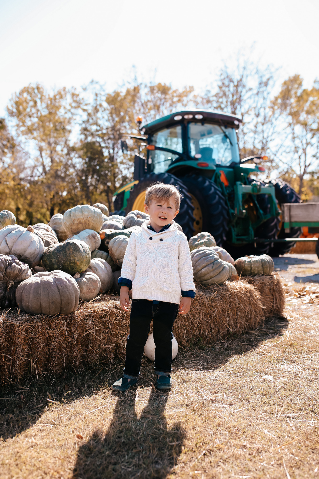 janie and jack kids clothing fall 2020, kids fall fashion 2020, the sweetest thing blog17 |janie and jack kids clothing fall 2020, kids fall fashion 2020, the sweetest thing blog17 | Janie and Jack Kids Clothing by popular US fashion blog, The Sweetest Thing: image of two kids sitting next to a pile of pumpkins and wearing a Janie and Jack PLAID POPLIN SHIRT, Janie and Jack SHAWL COLLAR PULLOVER, Janie and Jack SLIM SELVEDGE JEAN IN MOONLIGHT INDIGO WASH, Janie and Jack LEATHER TRIM BELT, Janie and Jack ARGYLE SOCK, Janie and Jack SUEDE DRIVING SHOE, and Janie and Jack PEPLUM BOW SWEATER.