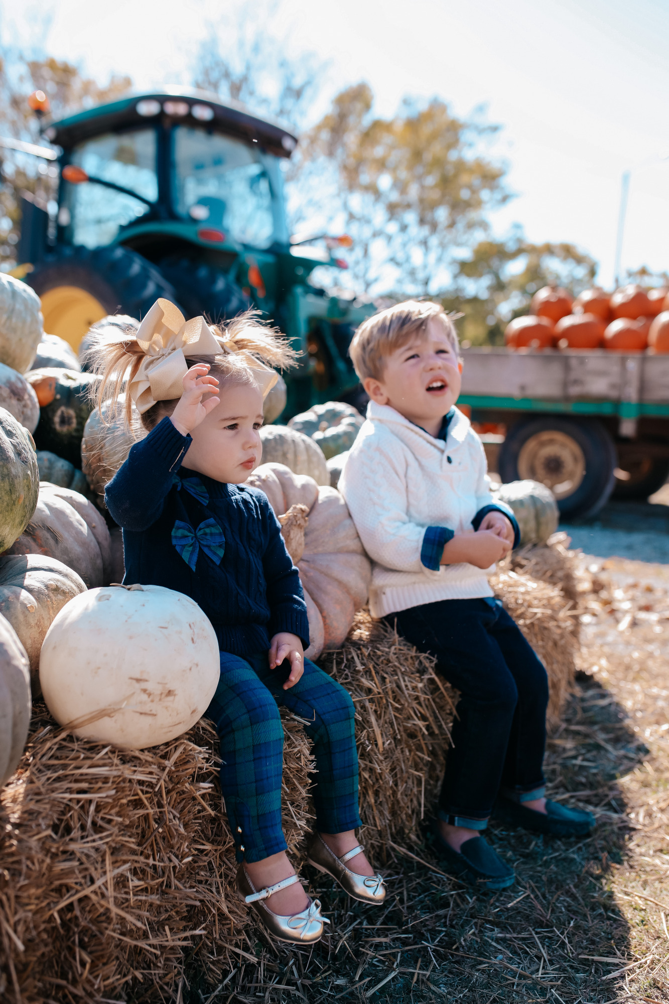 janie and jack kids clothing fall 2020, kids fall fashion 2020, the sweetest thing blog17 |janie and jack kids clothing fall 2020, kids fall fashion 2020, the sweetest thing blog17 | Janie and Jack Kids Clothing by popular US fashion blog, The Sweetest Thing: image of two kids sitting next to a pile of pumpkins and wearing a Janie and Jack PLAID POPLIN SHIRT, Janie and Jack SHAWL COLLAR PULLOVER, Janie and Jack SLIM SELVEDGE JEAN IN MOONLIGHT INDIGO WASH, Janie and Jack LEATHER TRIM BELT, Janie and Jack ARGYLE SOCK, Janie and Jack SUEDE DRIVING SHOE, Janie and Jack PEPLUM BOW SWEATER, Janie and Jack PLAID PONTE BUTTON CUFF PANT, and Janie and Jack METALLIC BOW FLAT.