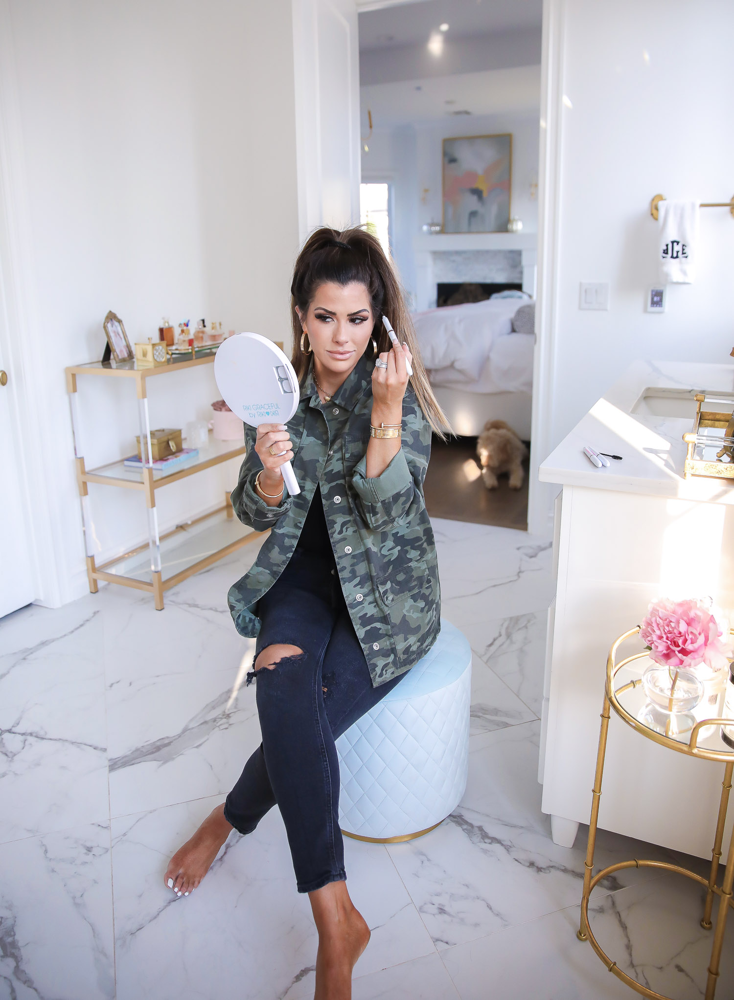 tarte DIY brow pen, national brow day, microblading brow pen, emily gemma, the sweetest thing blog |Brow Pencil by popular US beauty blog, The Sweetest Thing: image of Emily Gemma wearing a camo jacket and holding up a hand mirror while using a Tarte DIY brow pencil.