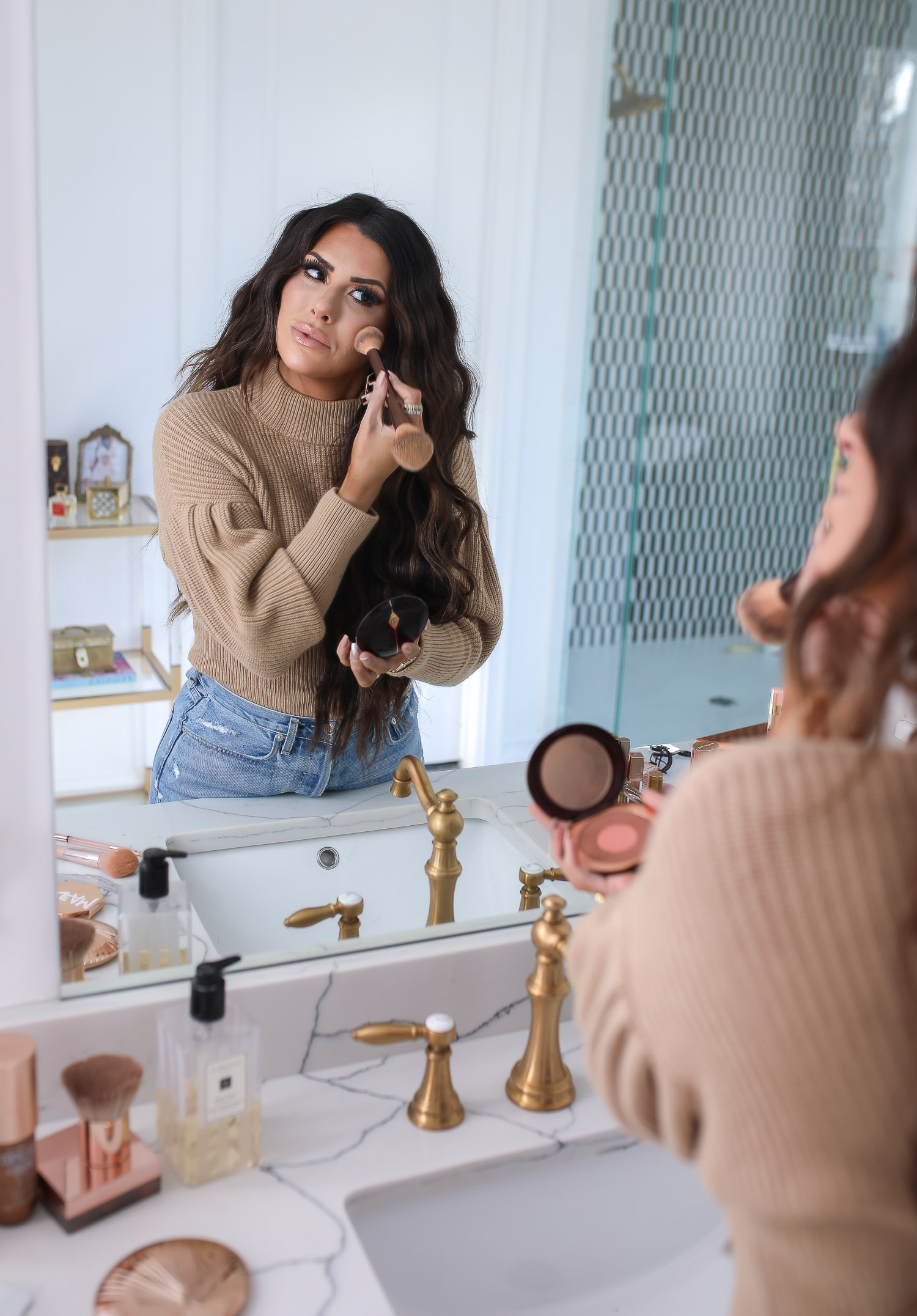 Sephora savings event fall 2020, beauty blogger sephora favorites fall 2020, emily ann gemma |Sephora Beauty Insider Sale by popular US beauty blog, The Sweetest Thing: image of Emily Gemma wearing a puff sleeve turtleneck sweater, Rolex watch, high waist distressed jeans and applying Sephora bronzer in her bathroom mirror. 