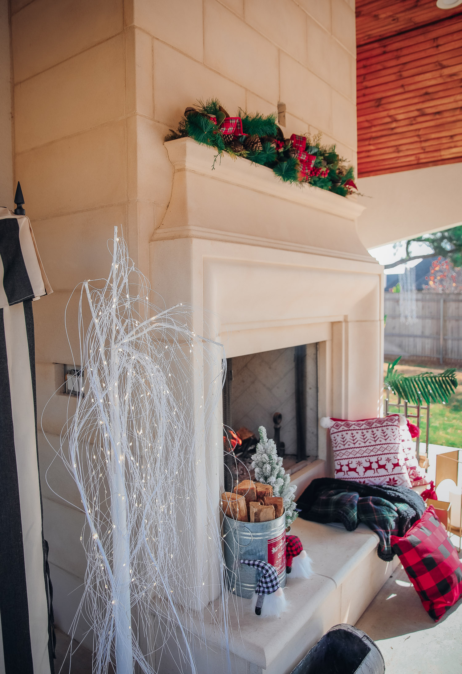 backyard decor christmas, outdoor pool christmas decor, walmart pool ornament, emily gemma backyard |Christmas Pool Decorations by popular US life and style blog, The Sweetest Thing: image of a pool house decorated with Christmas garland, black and red buffalo check throw pillows, Christmas tree decor, and Santa decor. 