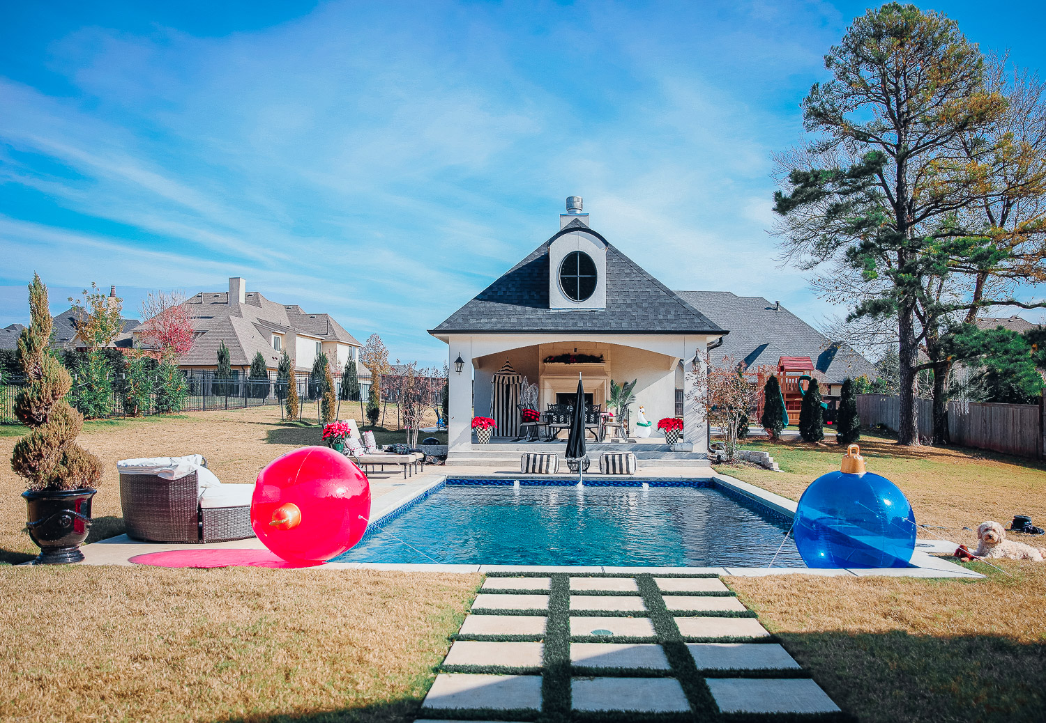 backyard decor christmas, outdoor pool christmas decor, walmart pool ornament, emily gemma backyard |Christmas Pool Decorations by popular US life and style blog, The Sweetest Thing: image of a pool house decorated with Christmas garland, black and red buffalo check throw pillows, Christmas tree decor, poinsettia plants, inflatable Christmas ornaments, and candles. 