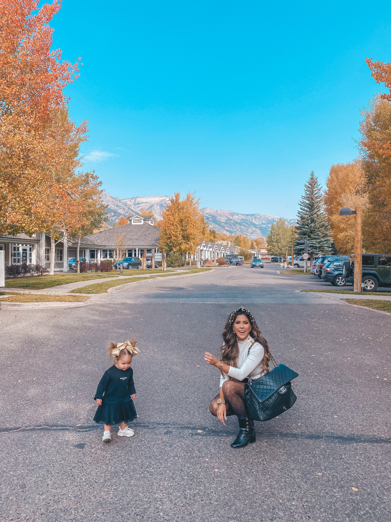 fall fashion pinterest outfits 2020, chanel combat boots black, tweed skirt with gucci tights, emily gemma fall outfit |Fall Clothing by popular US fashion blog, The Sweetest Thing: image of Emily Gemma walking outside with her young daughter and wearing a Express Novelty Button Mock Neck Top, Express High Waisted A-Line Tweed Mini Skirt, Chanel boots, Gucci tights, Cartier bracelet and pearl knot headband. 