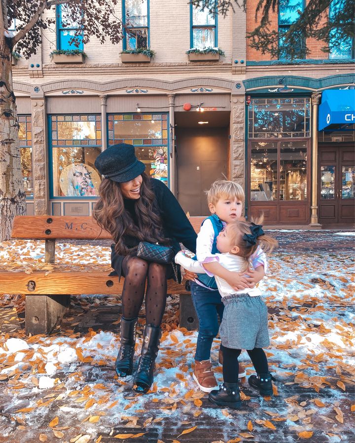November Instagram Recap by popular US lifestyle blog, The Sweetest Thing: image of Emily Gemma sitting outside on a bench with her son and daughter and wearing a Chanel dress, Chanel cap, Chanel ankle boots, Chanel tights, and Chanel black quilted purse. 