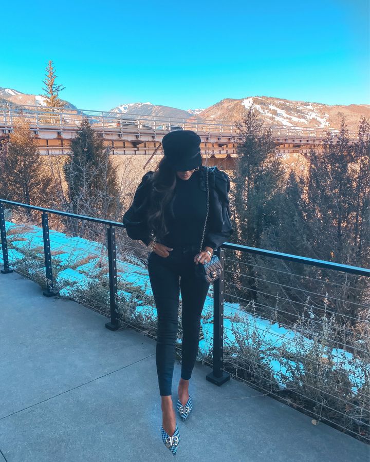 November Instagram Recap by popular US lifestyle blog, The Sweetest Thing: image of Emily Gemma wearing a Express black puff sleeve top, black Good American jeans, Balenciaga black and white checked point toe flats, Chanel black quilted purse, and black Chanel cap. 