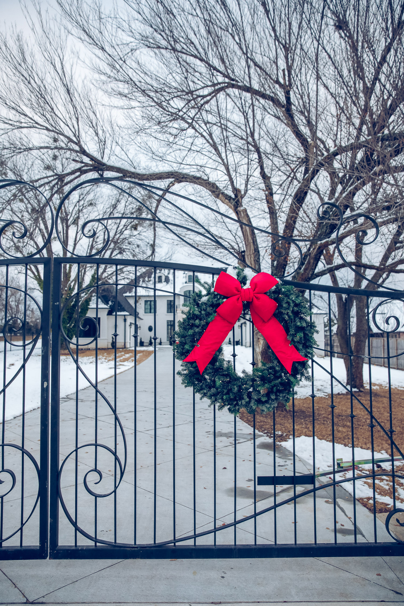 Christmas outdoor decorations home depot, emily gemma home, christmas wreaths on gates with bow, blow up nutcrackers, |Holiday Home Decor by popular US life and style blog, The Sweetest Thing: image of the front of a house decorated with nutcrackers and Christmas wreaths. 