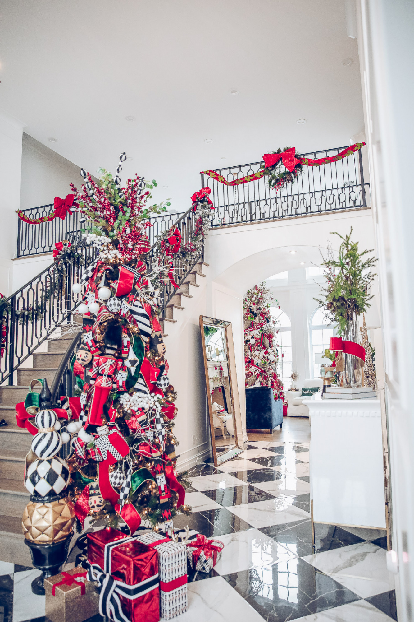 Christmas outdoor decorations home depot, emily gemma home, christmas wreaths on gates with bow, blow up nutcrackers, | Holiday Home Decor by popular US life and style blog, The Sweetest Thing: image of a entry way decorated with wreaths, holiday bows, faux garland, and a nutcracker Christmas tree. 