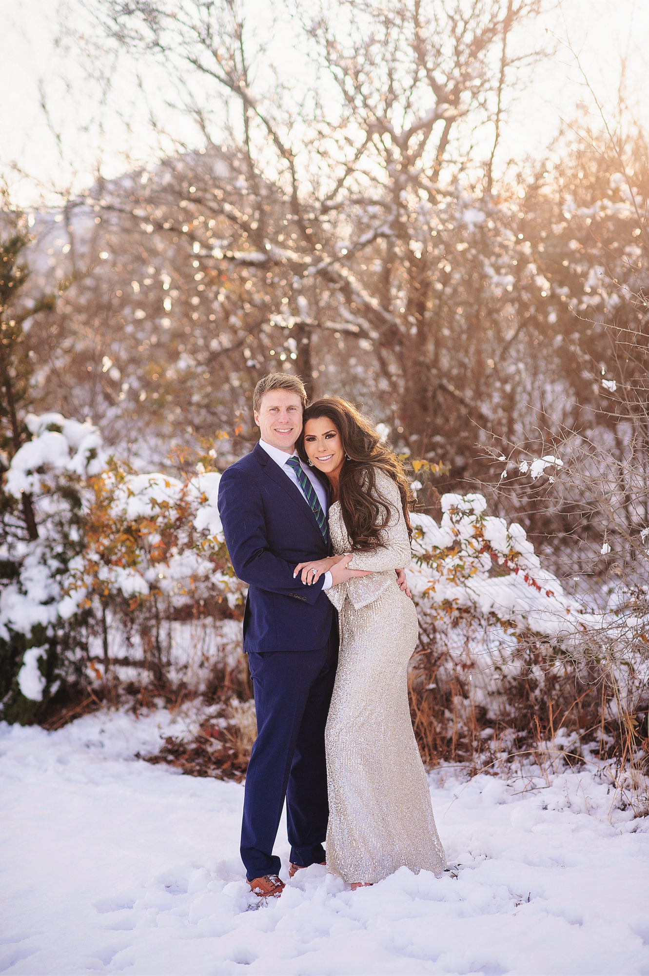 Family Christmas Card by popular US lifestyle blog, The Sweetest Thing: image of a husband and wife standing together in the snow and wearing a Eliza J sequin dress and blue suit with a blue and green stripe tie. 