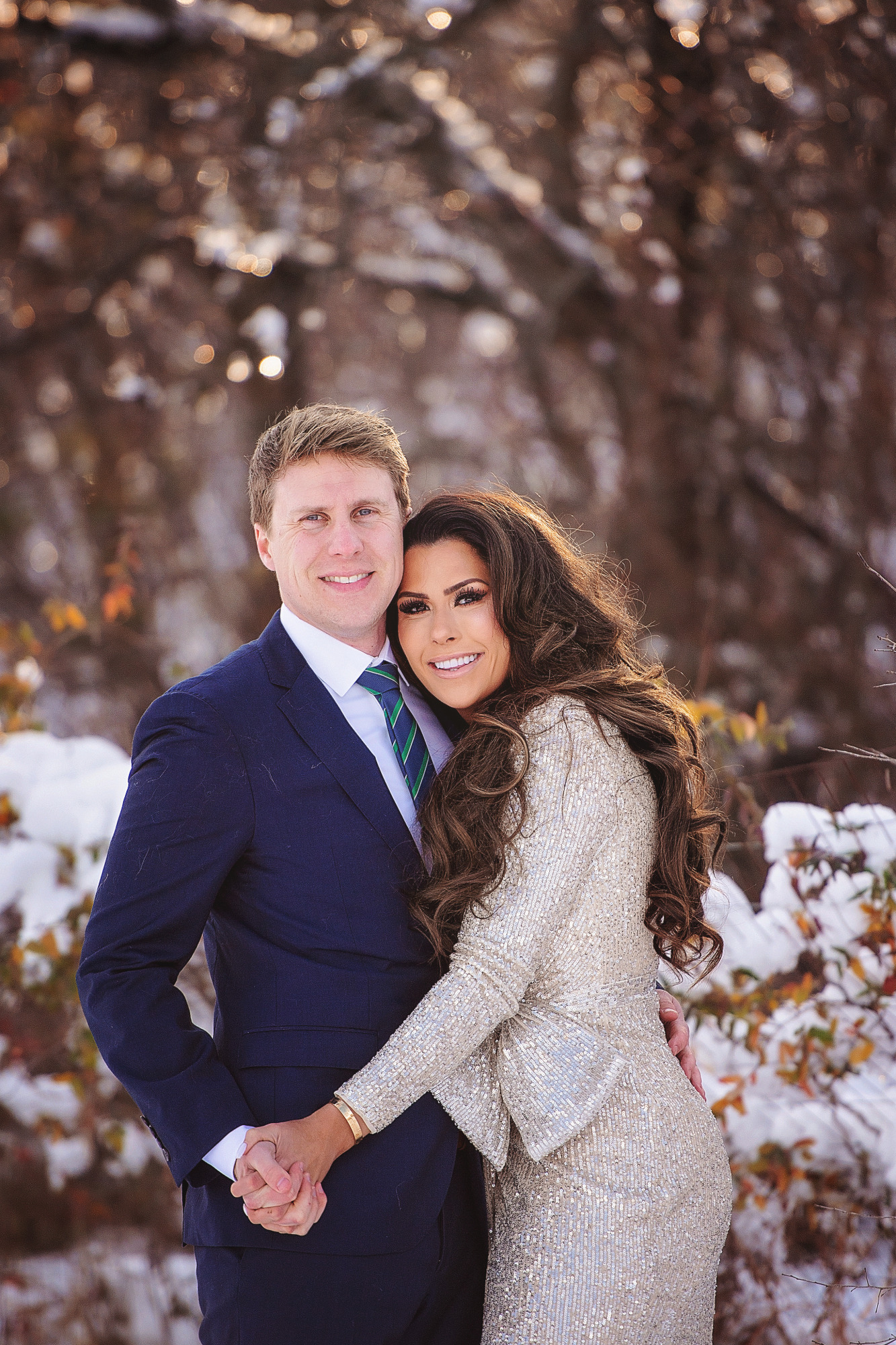 Family Christmas Card by popular US lifestyle blog, The Sweetest Thing: image of a husband and wife standing together in the snow and wearing a Eliza J sequin dress and blue suit with a blue and green stripe tie. 