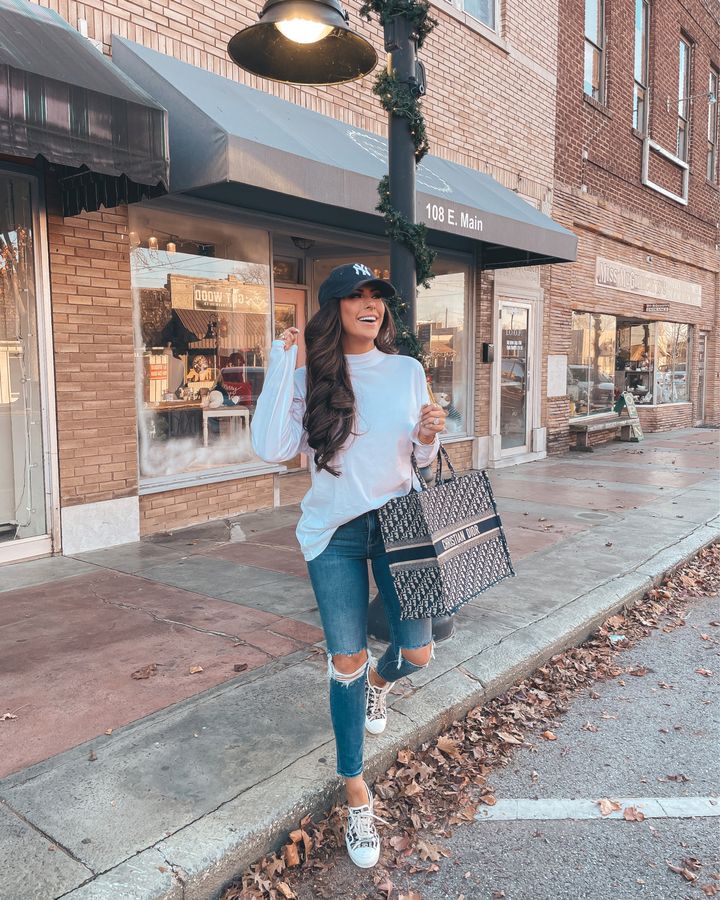 white long sleeve shirt, best white t-shirt 2021, ripped jeans, NY baseball cap, christian dior sneakers, christian dior tote bag, Emily Gemma 