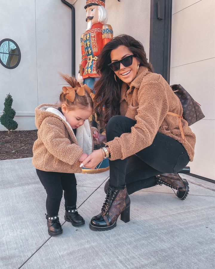 mommy and me outfit ideas, Louis Vuitton backpack, Louis Vuitton star trail ankle boot, black denim, sunglasses, gold hoop earrings