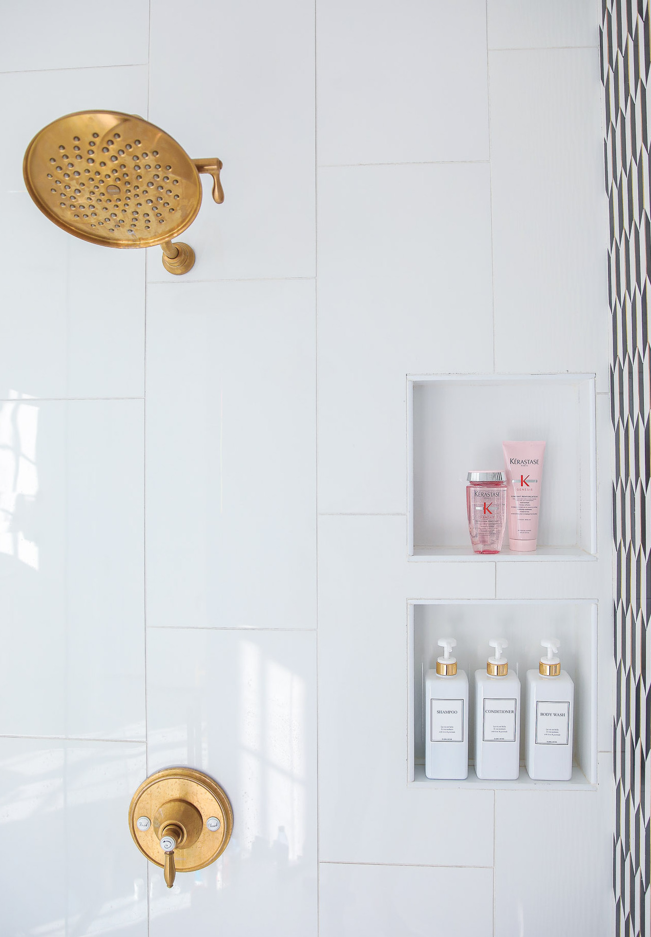 Top Picks by popular US life and style blog, The Sweetest Thing: image of Kerastase products in a white tile shower with a a gold faucet and gold shower head. 