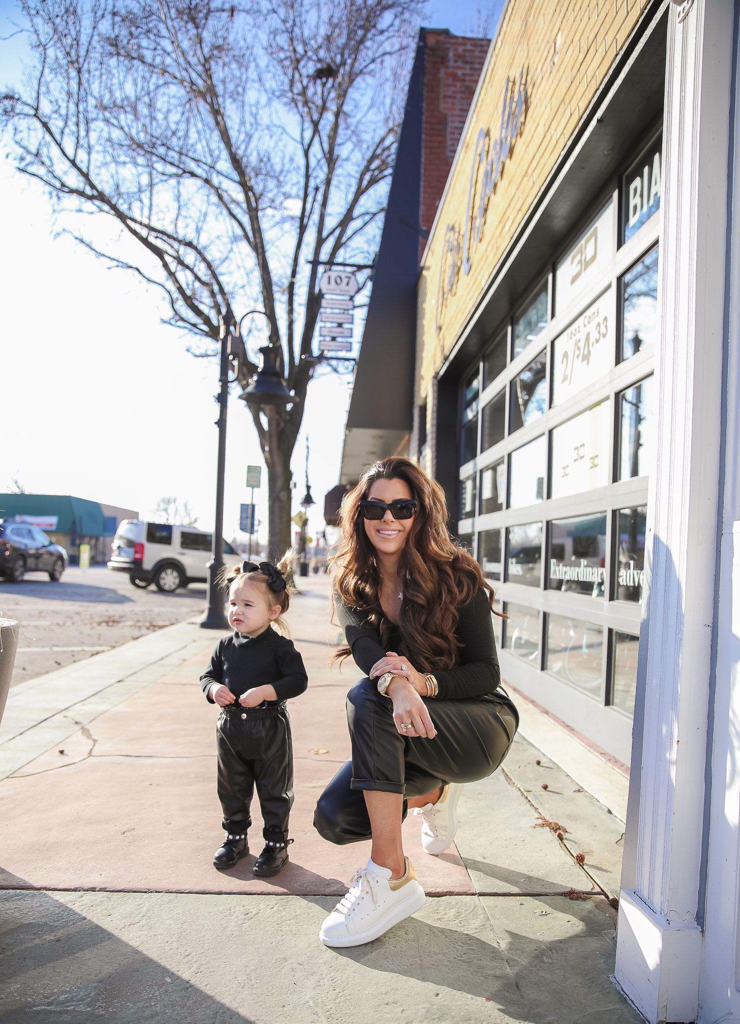 Nordstrom BP faux leather pants, loewe sunglasses, Alexander mcqueen sneakers gold white outfit pinterest, matching mommy daughter fashion, emily gemma |Mommy and Daughter by popular US fashion blog, The Sweetest Thing: image of a woman and her daughter walking together outside and wearing a pair of BP faux leather pants, Good American top, loewe sunglasses, Alexander mcqueen sneakers, Monica Vinader ring, Nadri bracelet, Nadri earrings, and Rolex watch.