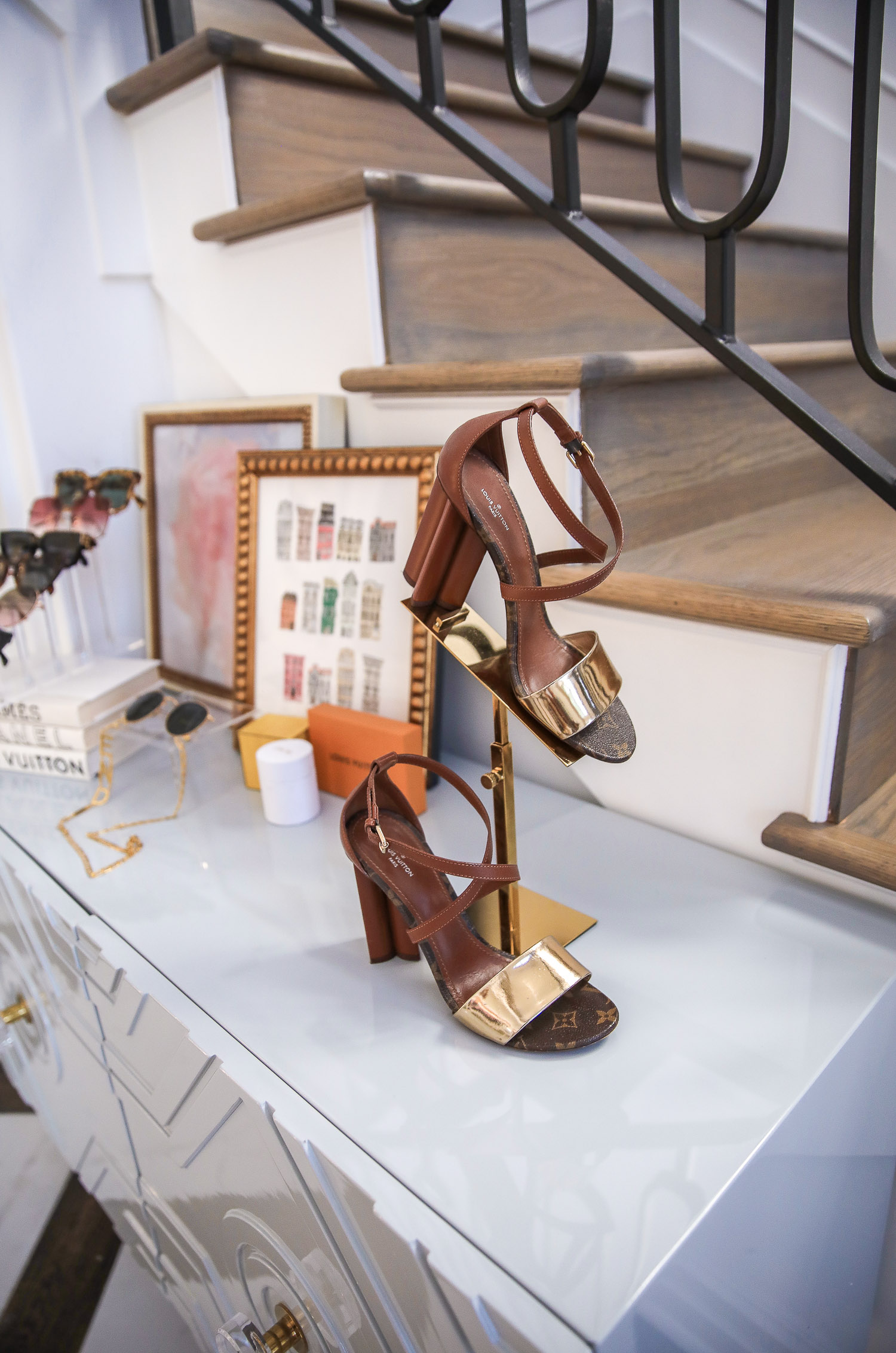 Top Picks by popular US life and style blog, The Sweetest Thing: image of Louis Vuitton sandals on a gold shoe stand. 
