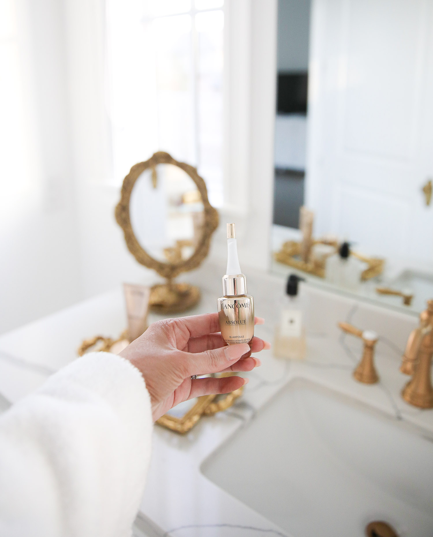 Lancome Skincare by popular US beauty blog, The Sweetest Thing: image of Emily Gemma holding a Lancome Absolue skincare product. 