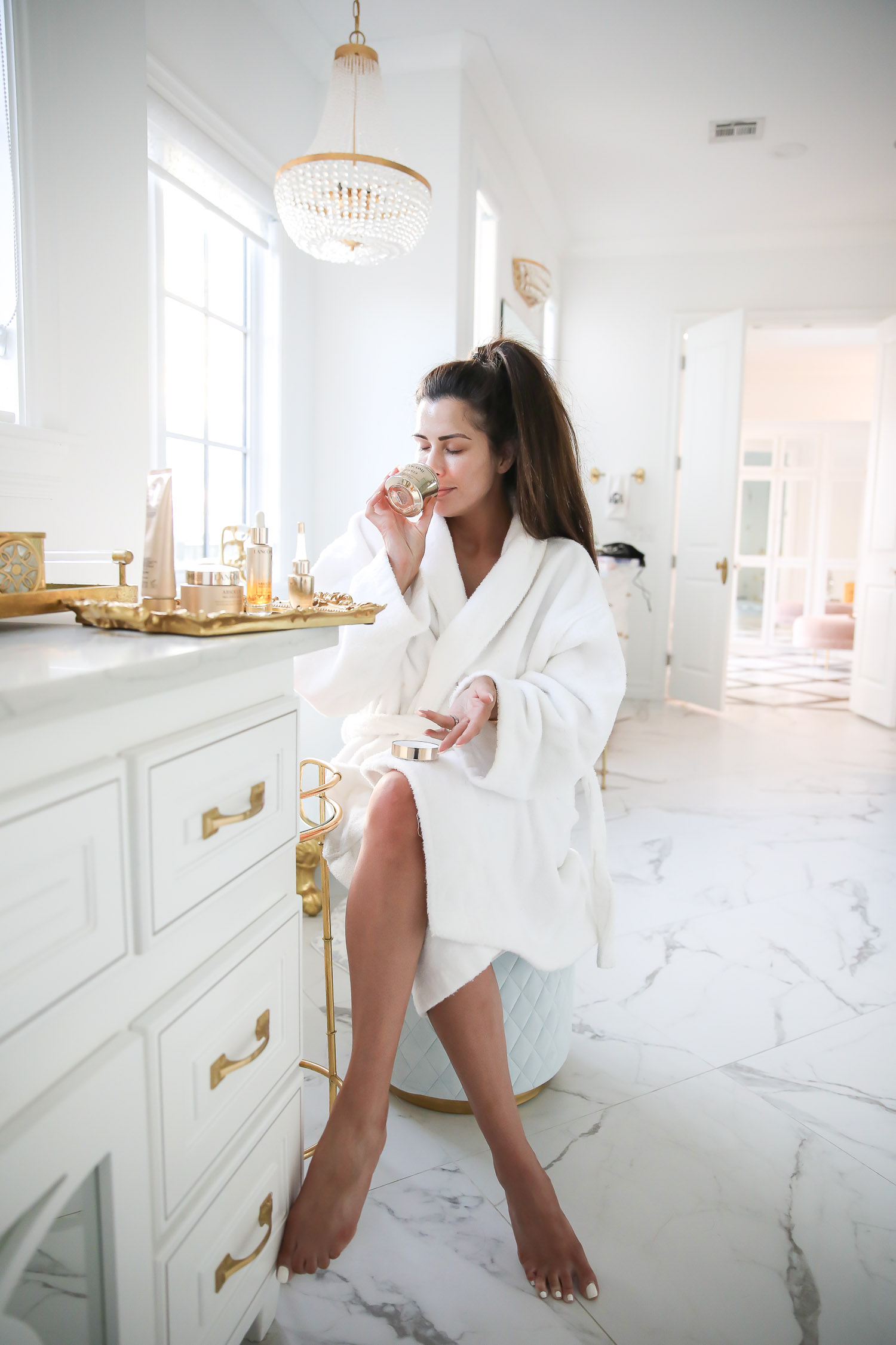Lancome Skincare by popular US beauty blog, The Sweetest Thing: image of Emily Gemma holding a Lancome Absolue skincare product. 