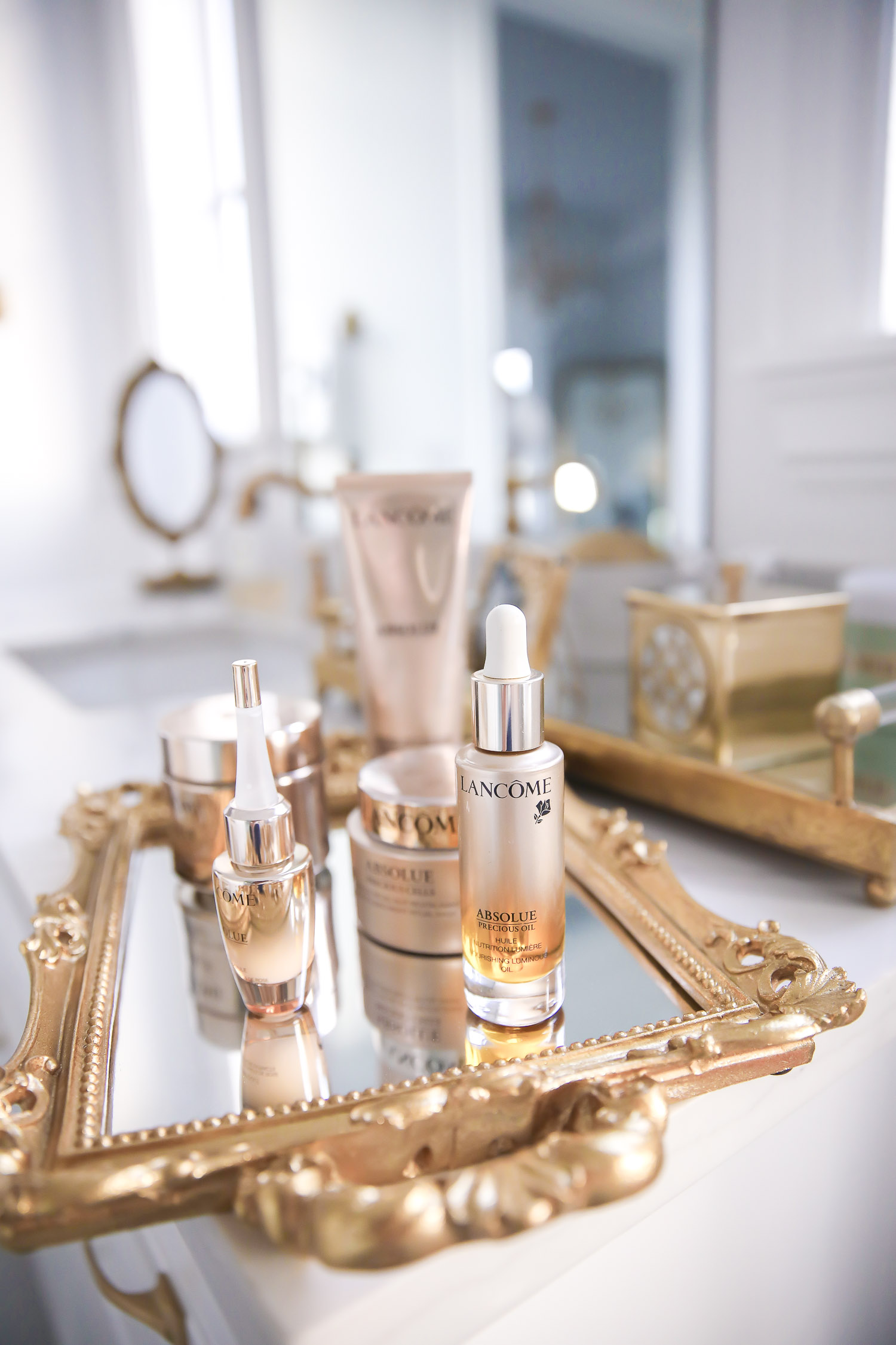 Lancome Skincare by popular US beauty blog, The Sweetest Thing: image of Lancome Absolue skincare products on a mirrored tray with gold handles. 