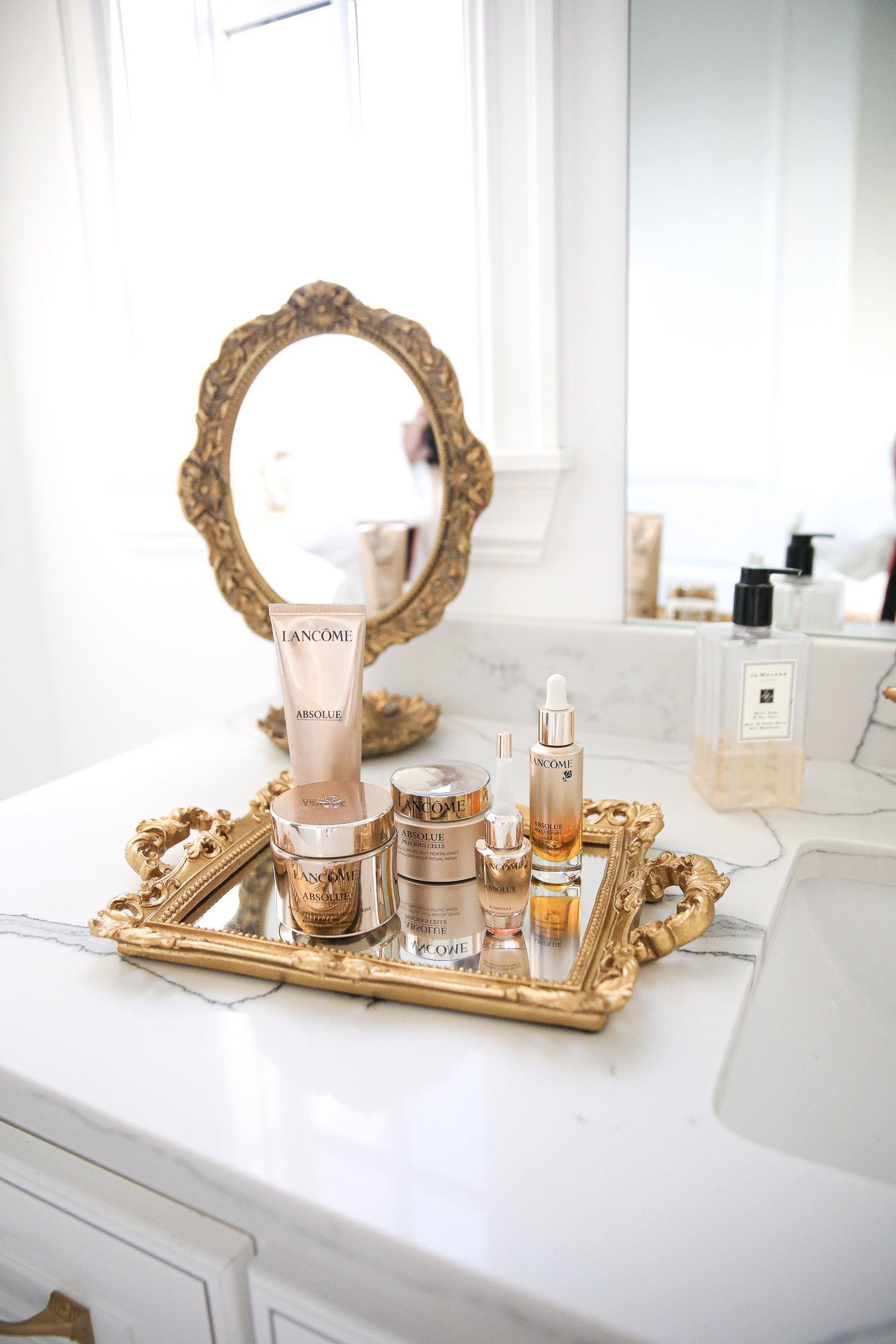 Lancome Skincare by popular US beauty blog, The Sweetest Thing: image of Lancome Absolue skincare products on a mirrored tray with gold handles. 