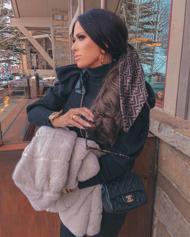 Fendi hair scarf, faux fur coat, Jackson hole outfit ideas, black puff sleeve sweater, chanel crossbody bag, Louis Vuitton gold earrings, Emily Gemma brunette hair, winter outfit ideas