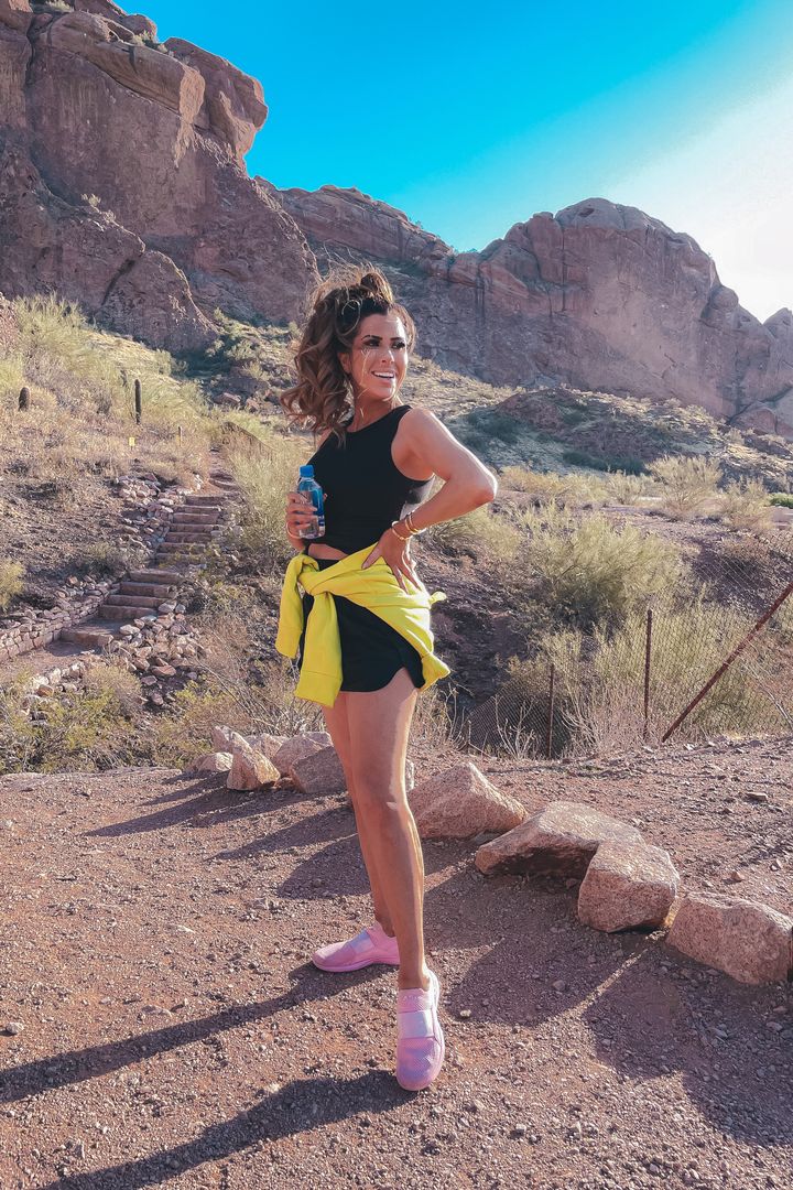 Athleisure, cute workout outfit ideas, hiking outfit, nike sweatshirt, nike pullover, apl footwear, pink tennis shoes, black workout shorts, best sports bra, camelback mountain, scottsdale Arizona, Emily Gemma |February Instagram Recap by popular US life and style blog, The Sweetest Thing: image of Emily Gemma wearing a Alo yoga top, Free People black shorts, APL pink sneakers and a Nike sweatshirt. 