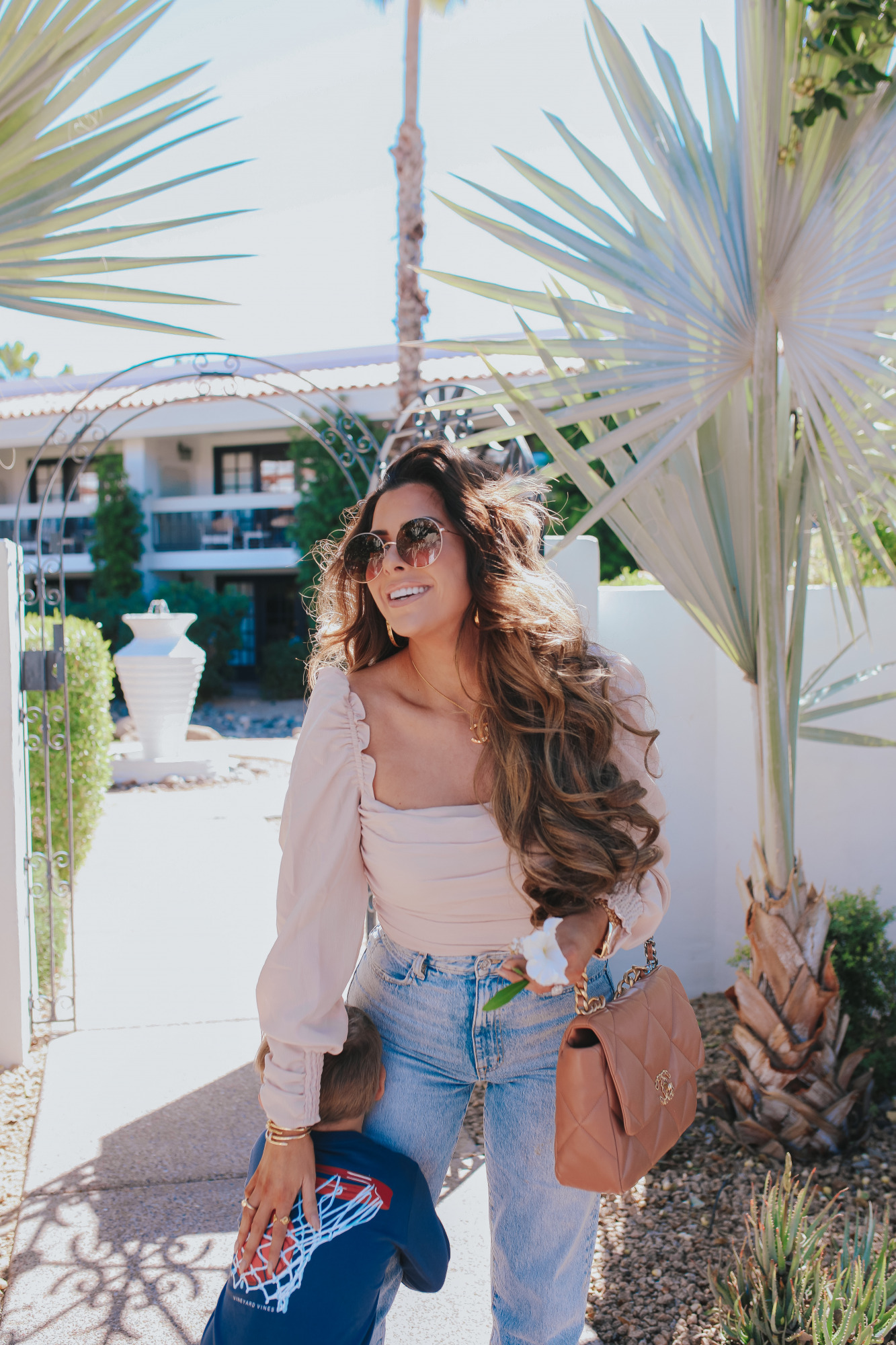 Chanel 19 flap tan brown medium, The Scott Scottsdale hotel, emily gemma, Mom jeans outfit 2021 |Mom Jeans by popular US fashion blog, The Sweetest Thing: image of Emily Gemma at standing outside in Scottsdale, Arizona and wearing Slvrlake mom jeans, Astr the Label top, gold Rolex watch, Cartier rings, Chanel purse, cartier bracelets, and Chanel necklace and hugging her son while he wears a Vineyard Vines t-shirt.