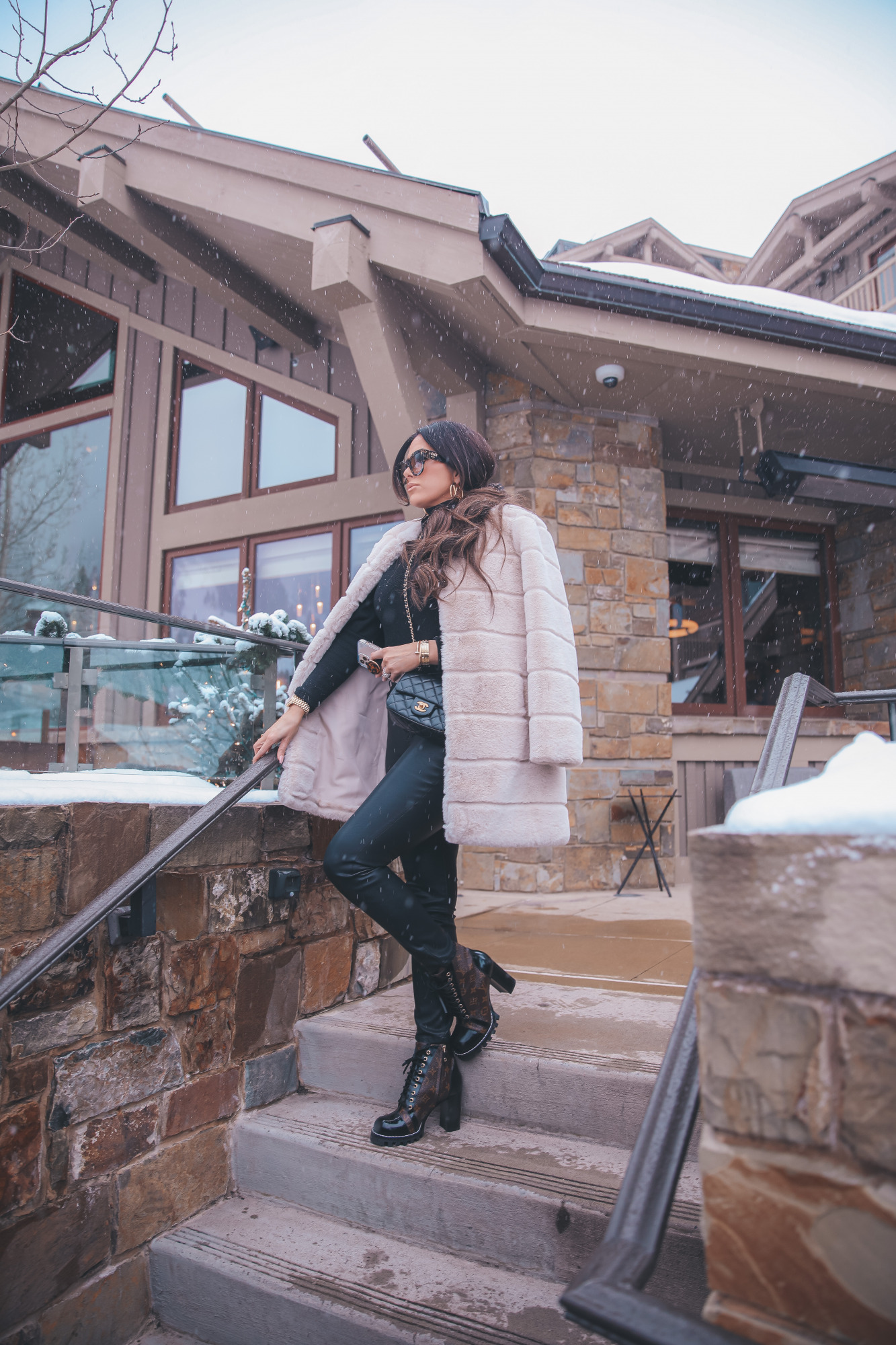 fendi hair scarf scrunchie, Louis Vuitton Star Trail Ankle Boots, Winter fashion pinteret 2021| Jackson Hole Winter by popular US fashion blog, The Sweetest Thing: image of Emily Gemma wearing a BB Dakota tan faux fur coat, black Express ruffle shoulder top, Fendi sunglasses, Black BlankNYC faux leather leggings, Louis Vuitton boots, Louis Vuitton earrings, and a Chanel black quilted purse. 