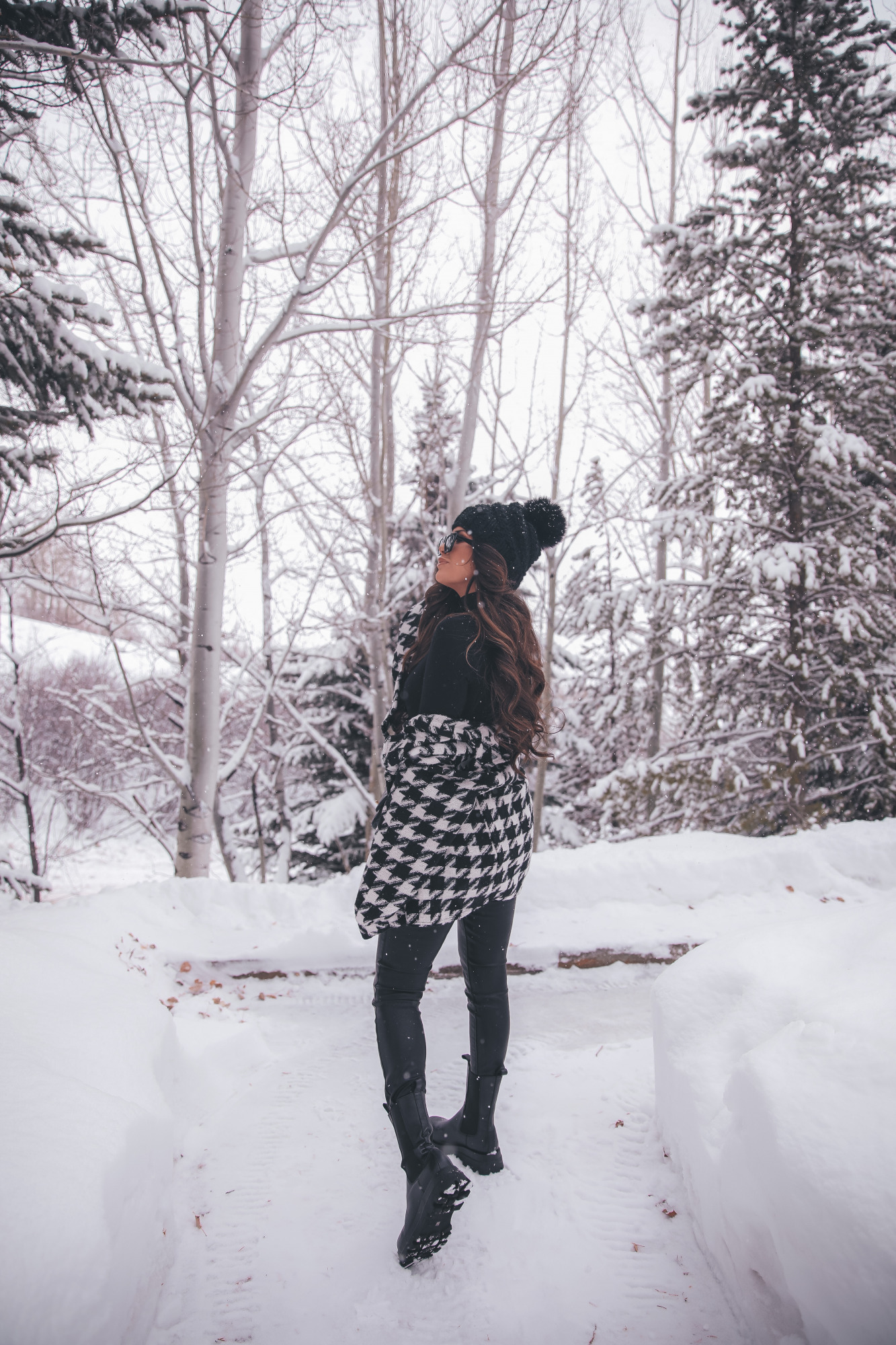 lug sole boots steve madden, shacket outfit ideas winter, jackson hole fashion winter |Lug Sole Boots by popular US fashion blog, The Sweetest Thing: image of Emily Gemma wearing a Storets black and white houndstooth jacket, Good American bodysuit, BlankNYC faux leather pants, Steve Madden black lug sole boots, BP. sunglasses, TopShop black pom beanie, Chanel handbag, Monica Vinader ring, Rolex watch, Cartier bracelets, and Iconic Nude' + KIM K.W. + White Russian Sparkle lip combo. 