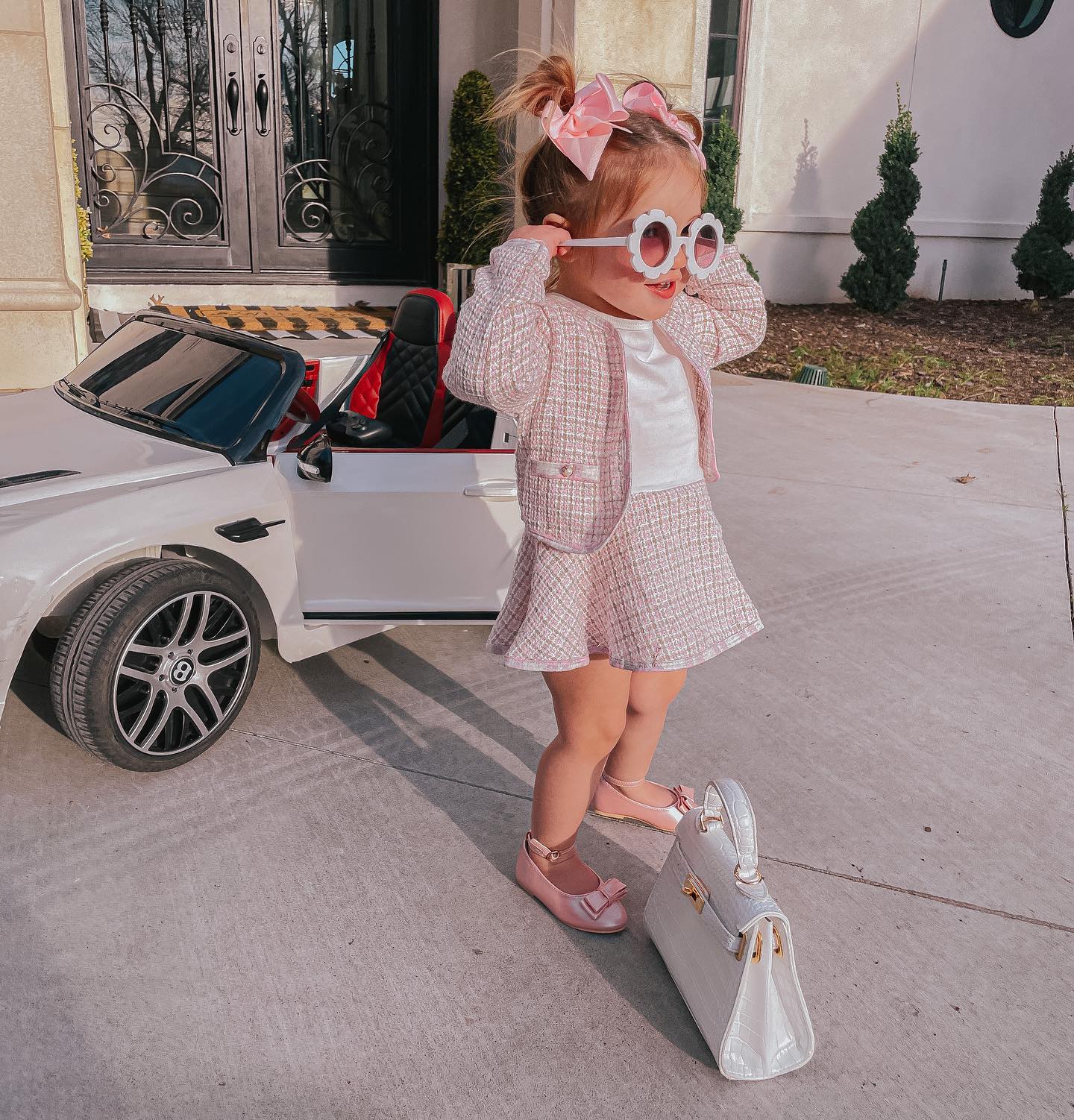 Gemma Gang, Best Toy Cars for Kids, Little Girl Preppy Outfit, Little Girl Sunglasses, Bows for Little Girls, Baby Birkin |Instagram Recap by popular US fashion blog, The Sweetest Thing: image of a little girl standing next to a battery powered Bentley and baby Birkin bag while wearing a pink tweed skirt suit, pink box, white shirt, and white flower frame sunglasses. 