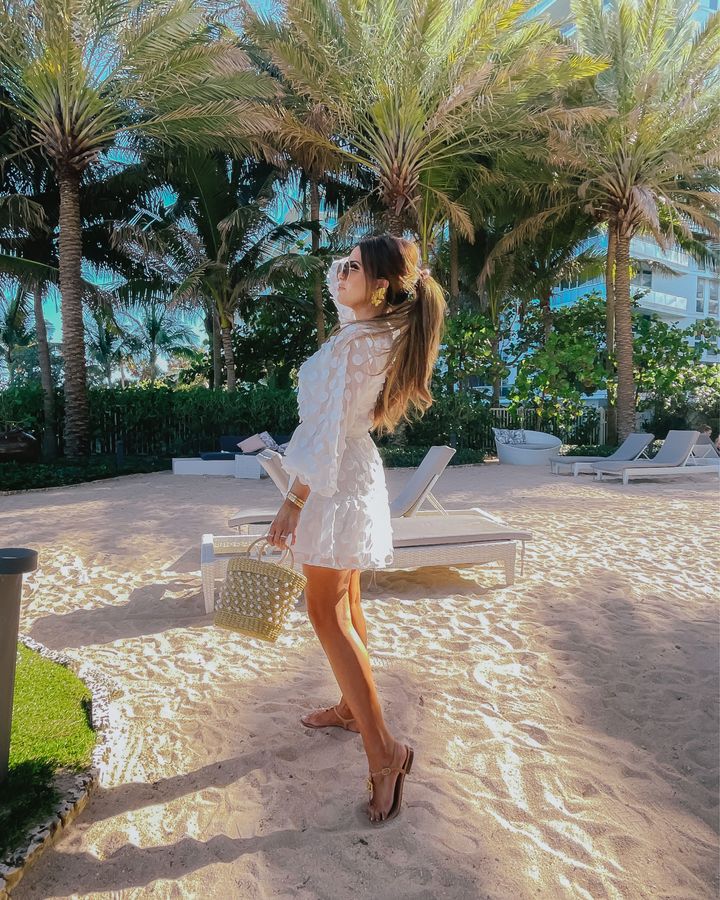 Emily Ann Gemma, Summer Style, Beach Style, What to wear to the beach, Bachelorette Dress Ideas, Bridal Shower Outfit Ideas, Bridal Shower Dress, Rehearsal Dinner Dress, White Dress, Summer Style, Easter Dress |Instagram Recap by popular US fashion blog, The Sweetest Thing: image of Emily Gemma standing on a beach next to some palm trees and wearing a white mini dress and brown strap sandals. 