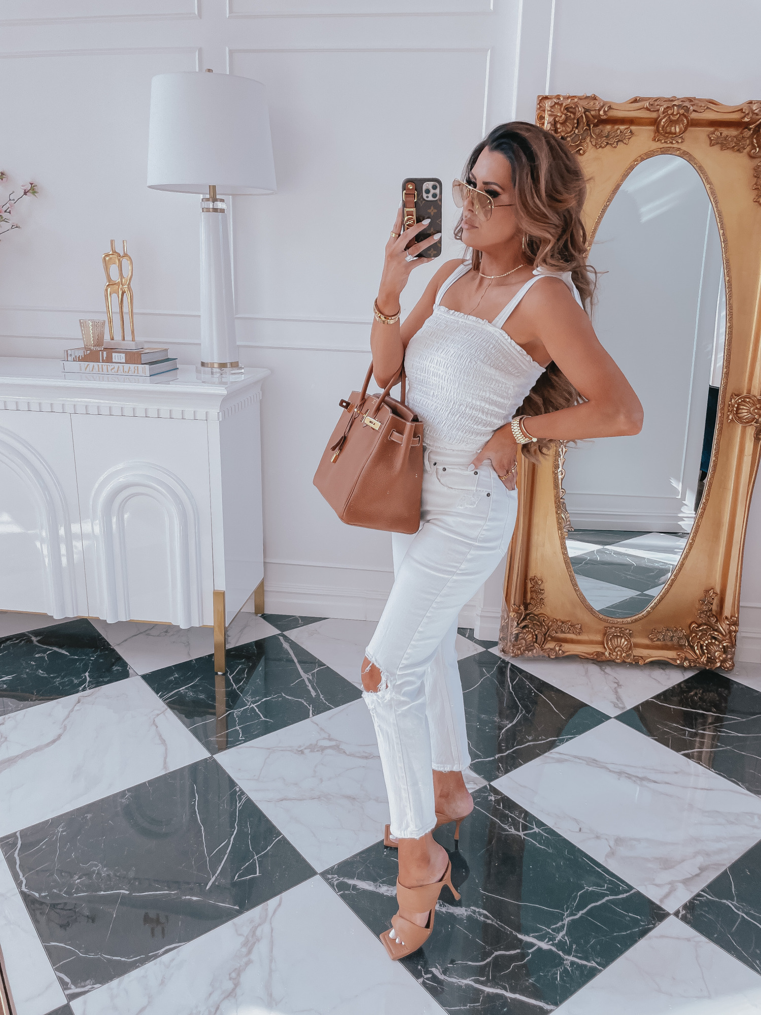 LTK Day Sale Spring 2021, Abercrombie Spring Fashion 2021, emily gemma |Best Sales This Weekend by popular US fashion blog, The Sweetest Thing: image of Emily Gemma wearing a white smocked top with white jeans, beige heel slide sandals, and holding a brown purse. 
