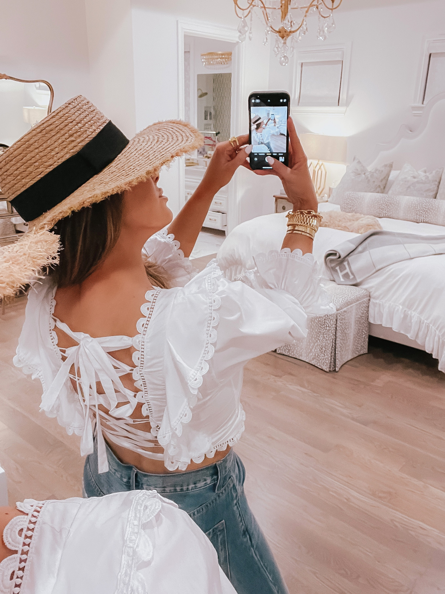 Vici Try On by popular US fashion blog, The Sweetest Thing: image of Emily Gemma wearing a white corset back crop top, jeans, and straw sun hat.  