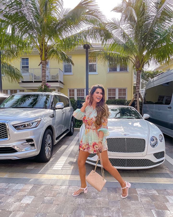 Palm Beach, Pink Chanel, Chanel Handbag, White Bentley, Zimmerman Outfit, Floral Shorts and Top, Emily Gemma \ April Instagram Recap by popular US fashion blog, The Sweetest Thing: image of Emily Gemma standing in front of a white Bentley and wearing a blue floral print romper and pink strap block heel sandals. 
