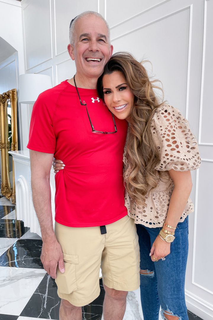 Express top ideas, Emily Ann Gemma, tan blouse and jeans with rips in the knees, casual spring outfit ideas 2021, affordable outfit ideas, designer look alike fashion | Instagram Recap by popular US life and style blog, The Sweetest Thing: image of Emily Gemma wearing a tan eyelet puff sleeve top and distressed jeans and standing with her arm around her dad. 