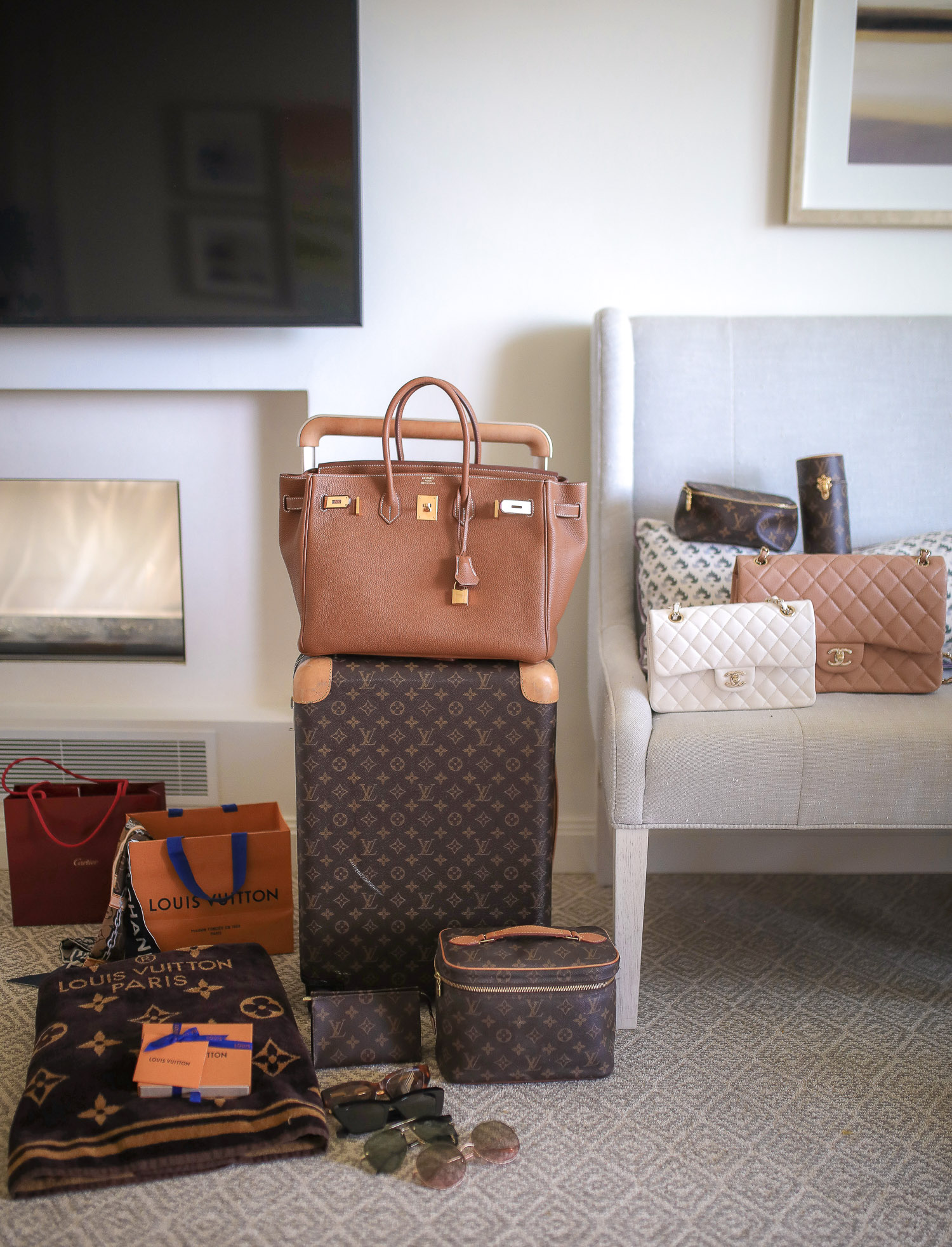 Louis Vuitton Horizon 55 carry on, Hermes berkin 35 tan gold hardware, Louis Vuitton beach towel, Emily Gemma | Travel Hacks by popular life and style blog, The Sweetest Thing: image of Louis Vuitton luggage, Louis Vuitton blanket, Louis Vuitton makeup bag, Chanel purses, and designer sunglasses. 