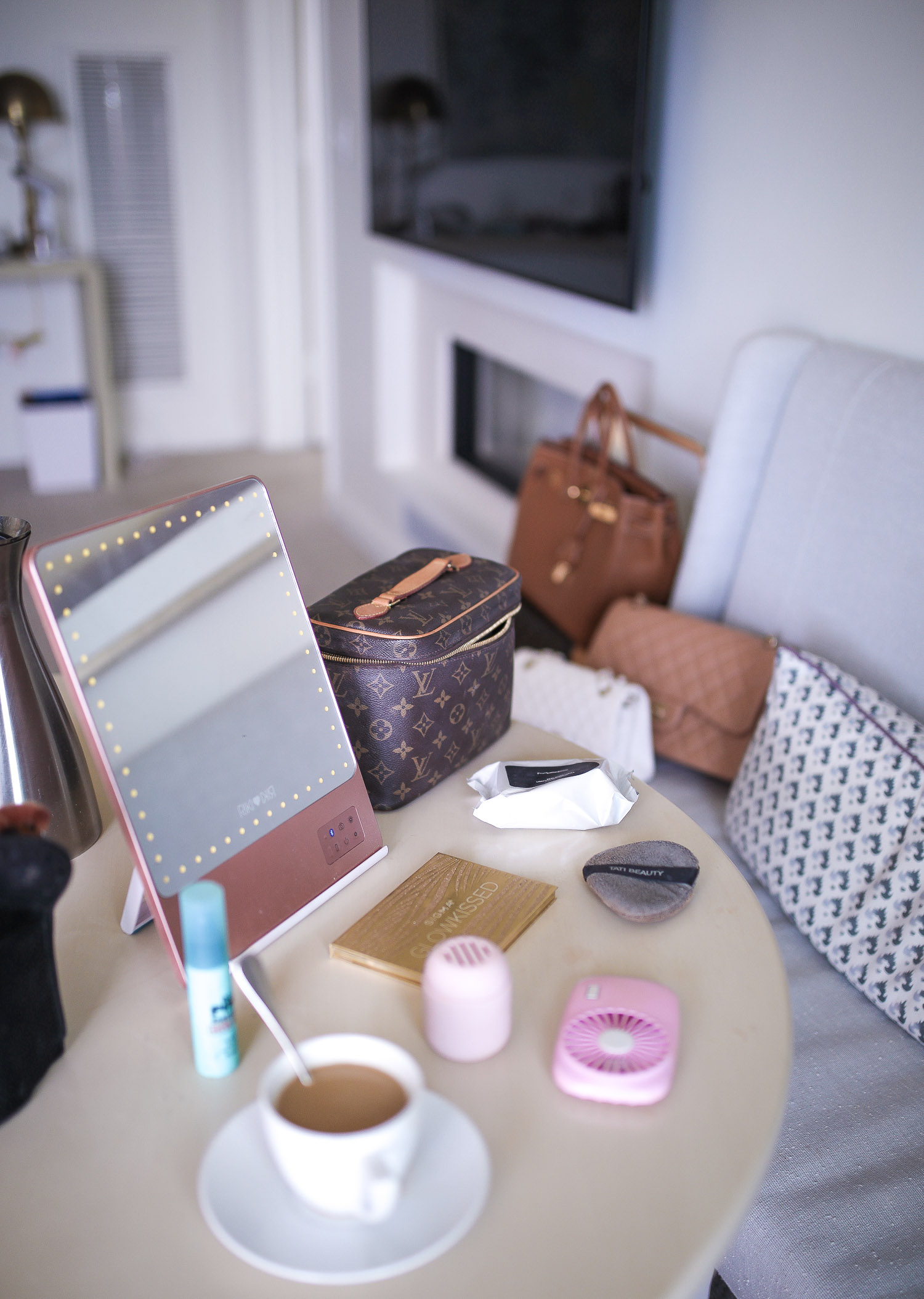 Riki Size Travel Mirror, pink travel fan makeup, beauty sponge holder travel amazon, Louis Vuitton Nice Case, Emily Gemma | Travel Hacks by popular life and style blog, The Sweetest Thing: image of a makeup mirror, Louis Vuitton makeup bag, portable fan, and cup of coffee. 