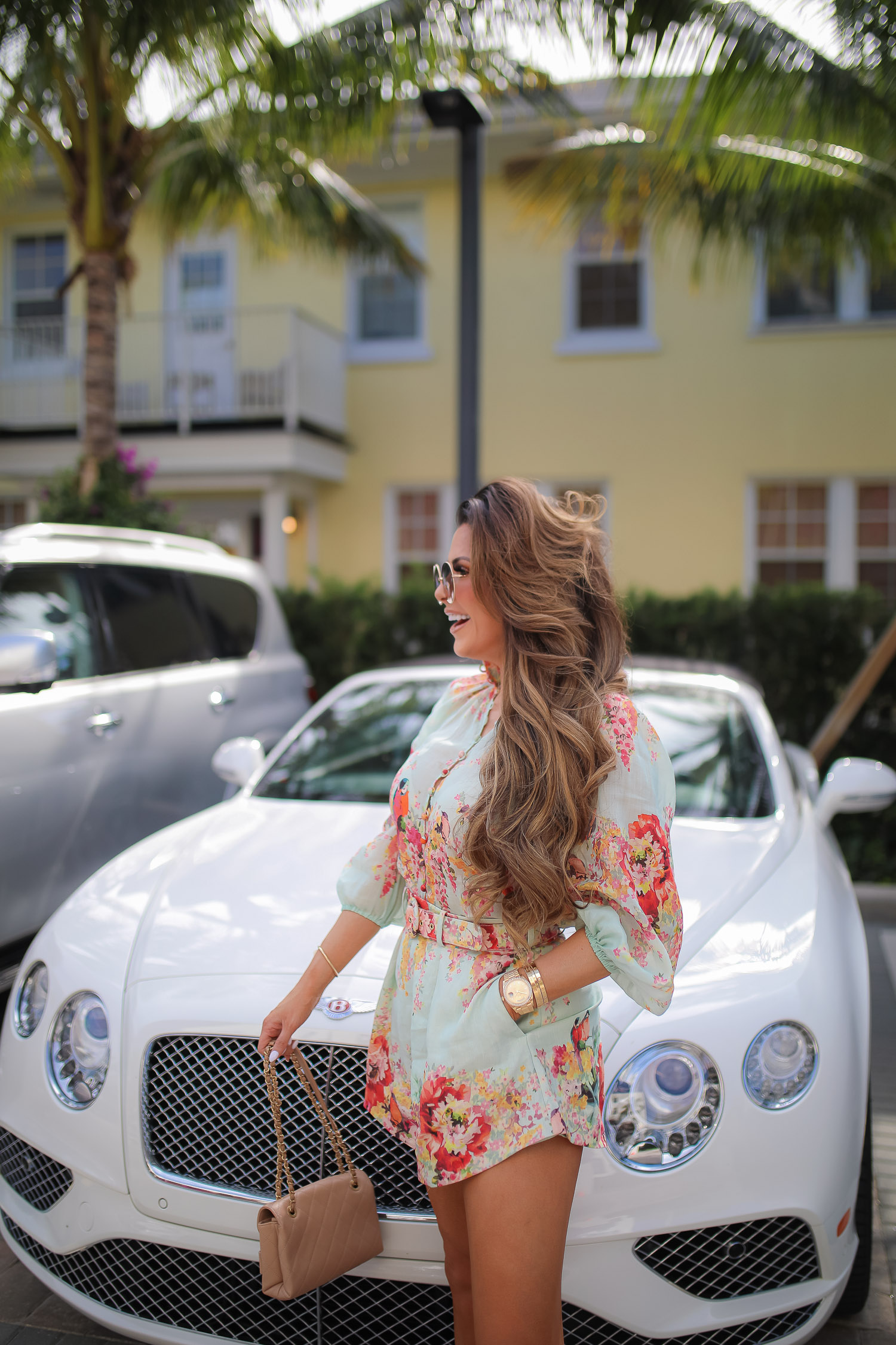 Palm beach where to stay, White elephant palm beach, Zimmerman Mae Floral Shorts and Blouse, Tiktok viral jewelry anklet, Amazon Tiktok Viral anklet, Chanel Large Button Paris Gold earrings, high end fashion blog, Emily gemma, the sweetest thing blog, luxury travel blog, palm beach white elephant | Zimmermann Outfit by popular US fashion blog, The Sweetest Thing: image of Emily Gemma standing by a white Bentley and wearing a Zimmerman Mae Floral Shorts and Blouse, Tiktok viral jewelry anklet, Amazon Tiktok Viral anklet, Chanel Large Button Paris Gold earrings, Cartier bracelets, gold Rolex watch, and carrying a Chanel handbag.  