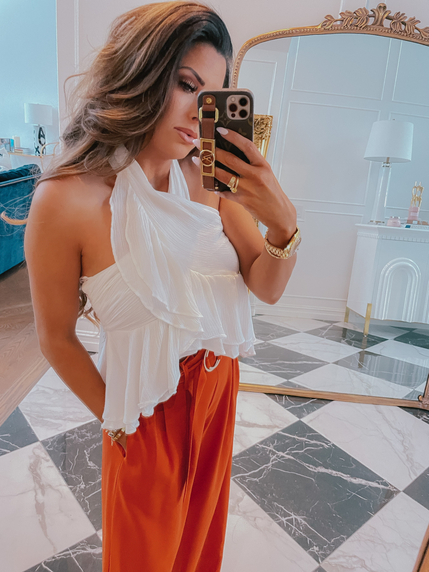 summer outfit ideas, white top, high waisted pants, red dress boutique try on haul, Emily Ann gemma | Instagram Recap by popular US life and style blog, The Sweetest Thing: image of Emily Gemma wearing a white ruffle halter top with orange high waist wide leg pants and gold jewelry. 