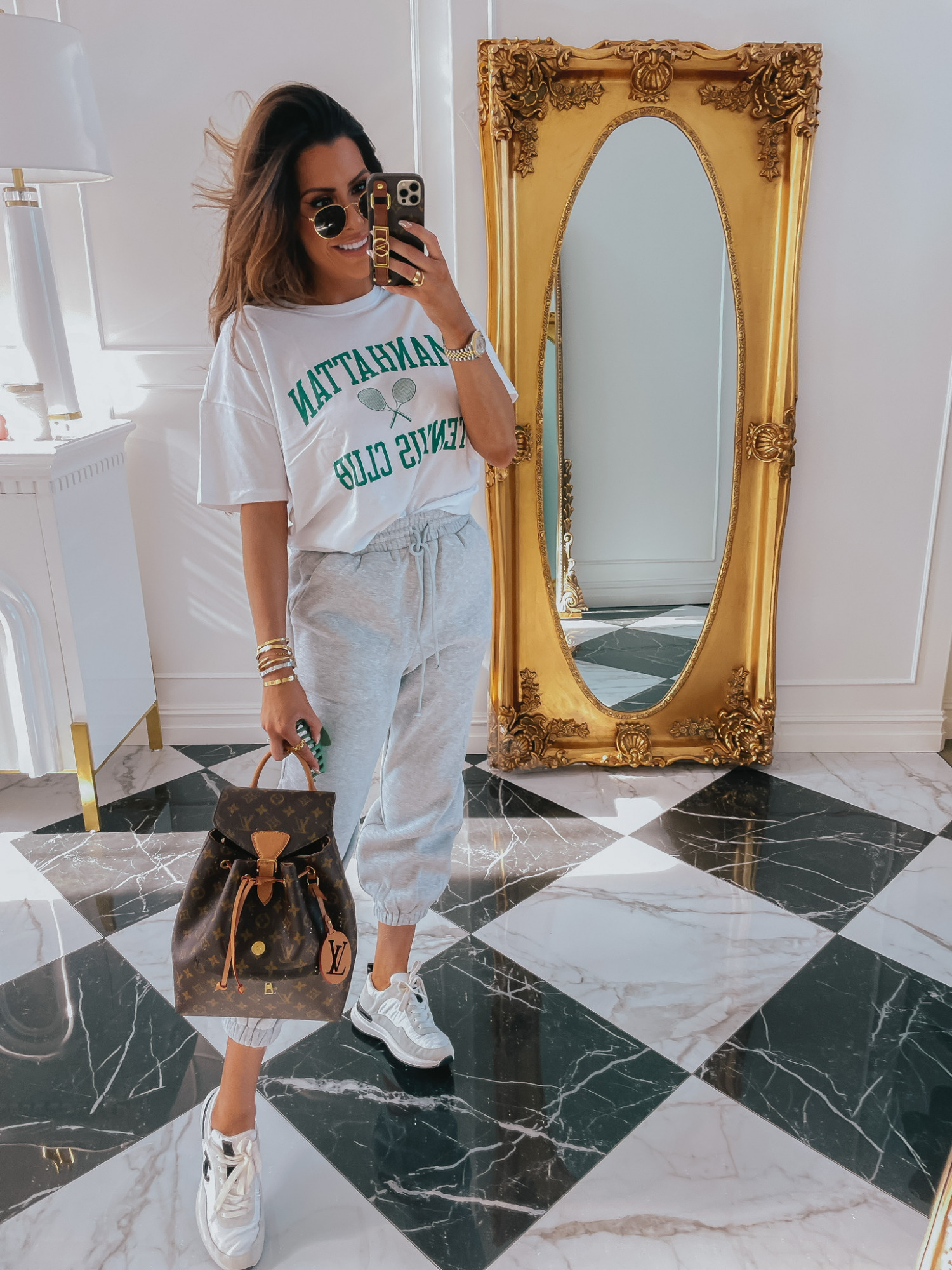 Emily-ann-gemma-abercrombie-tee-shirt-sweatpants-outfit-ltk-day-sale | LTK Sales by popular US fashion blog, The Sweetest Thing: image of Emily Gemma wearing a Manhattan Tennis Club shirt, grey sweatpants and sneakers. 