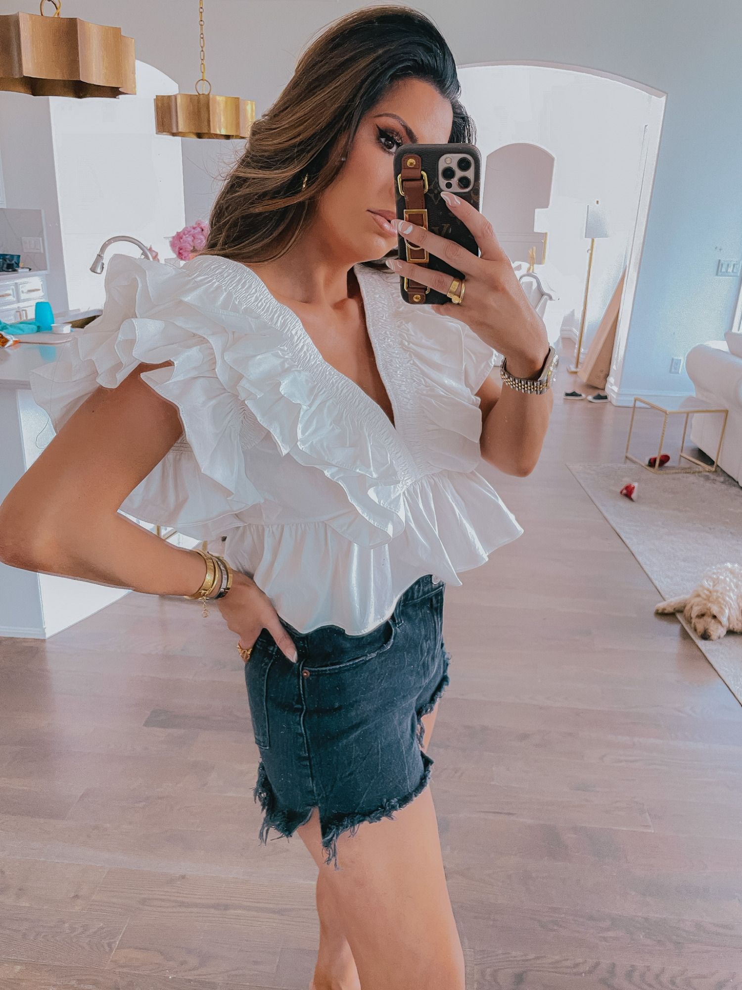 LTK Sales by popular US fashion blog, The Sweetest Thing: image of Emily Gemma wearing a white v-neck ruffle blouse with cutoff black denim shorts. 