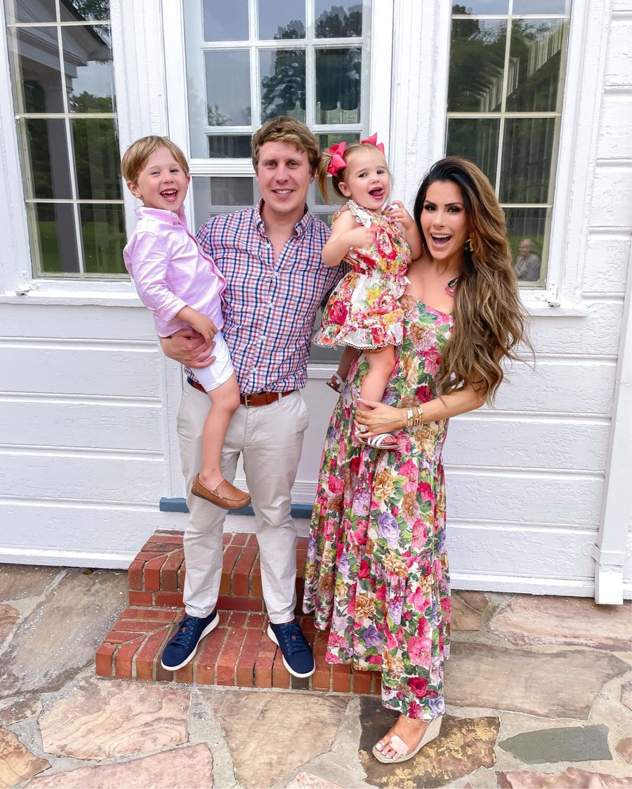 the gemma family, the gemma gang, Emily gemma, mommy daughter Zimmermann outfits, long floral dress, family photo ideas, best summer dresses for mom and daughter | June Instagram Recap by popular US fashion blog, The Sweetest Thing: image of Emily Gemma and her family standing together and wearing a pink button up shirt, white shorts, brown loafers, khaki pants, red white and blue plaid button up, floral print dress, pink hair bows, and floral print maxi dress with clear strap wedges. 