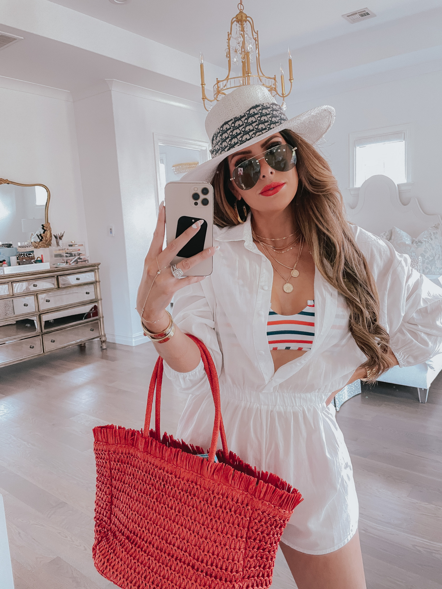 july 4 outfit inspiration 2021, pinterest july 4 outfit, dior scarf tied around hat, Emily gemma | June Instagram Recap by popular US fashion blog, The Sweetest Thing: image of Emily Gemma wearing a white straw hat, white romper, white, red and blue stripe swimsuit top and holding a red straw tote bag. 