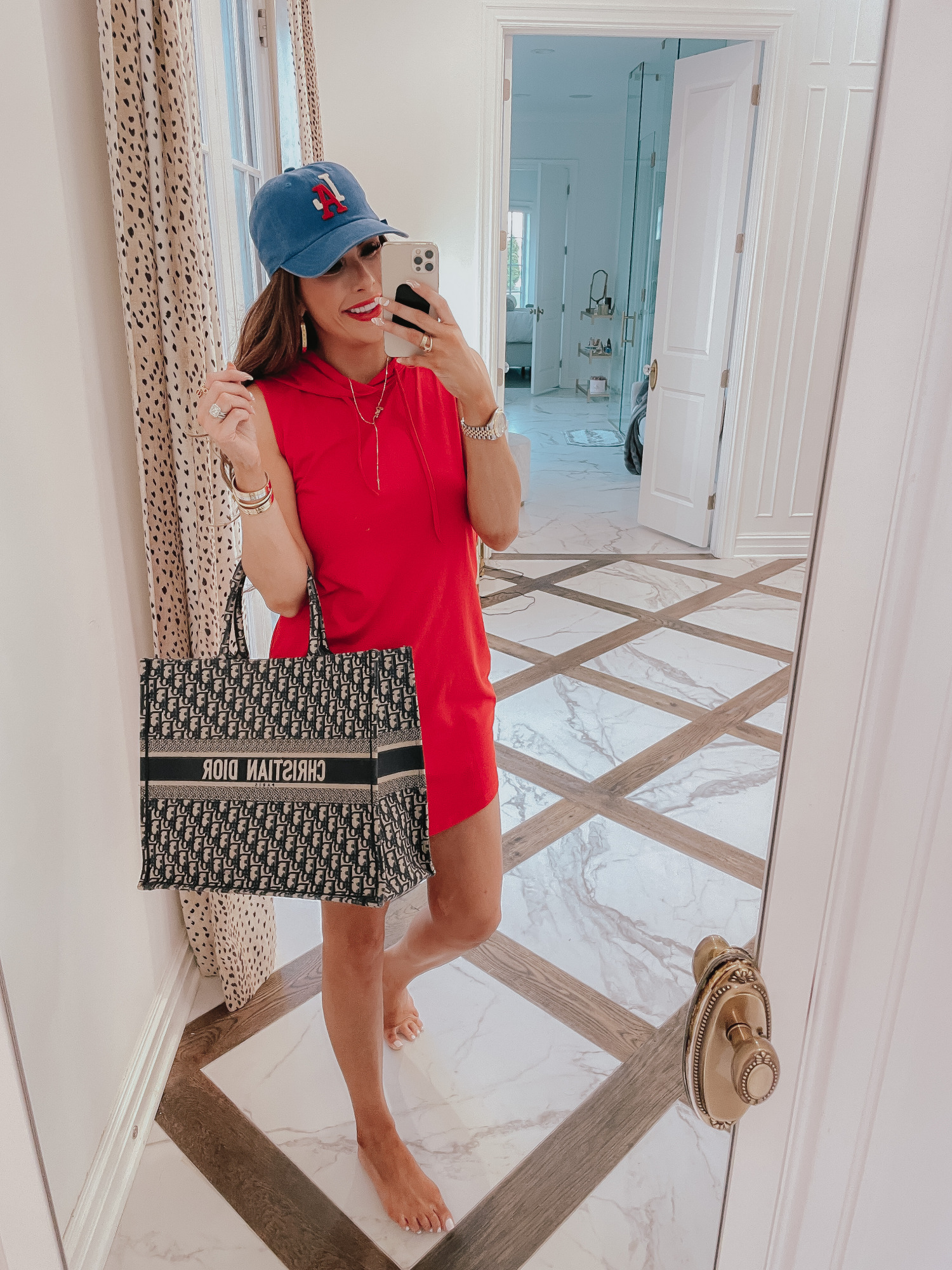july 4 outfit inspiration 2021, pinterest july 4 outfit, gucci red lipstick, dior book tote navy, Emily gemma | June Instagram Recap by popular US fashion blog, The Sweetest Thing: image of Emily Gemma wearing a blue baseball cap, red sleeveless hoodie dress, and holding a Christian Dior tote bag. 