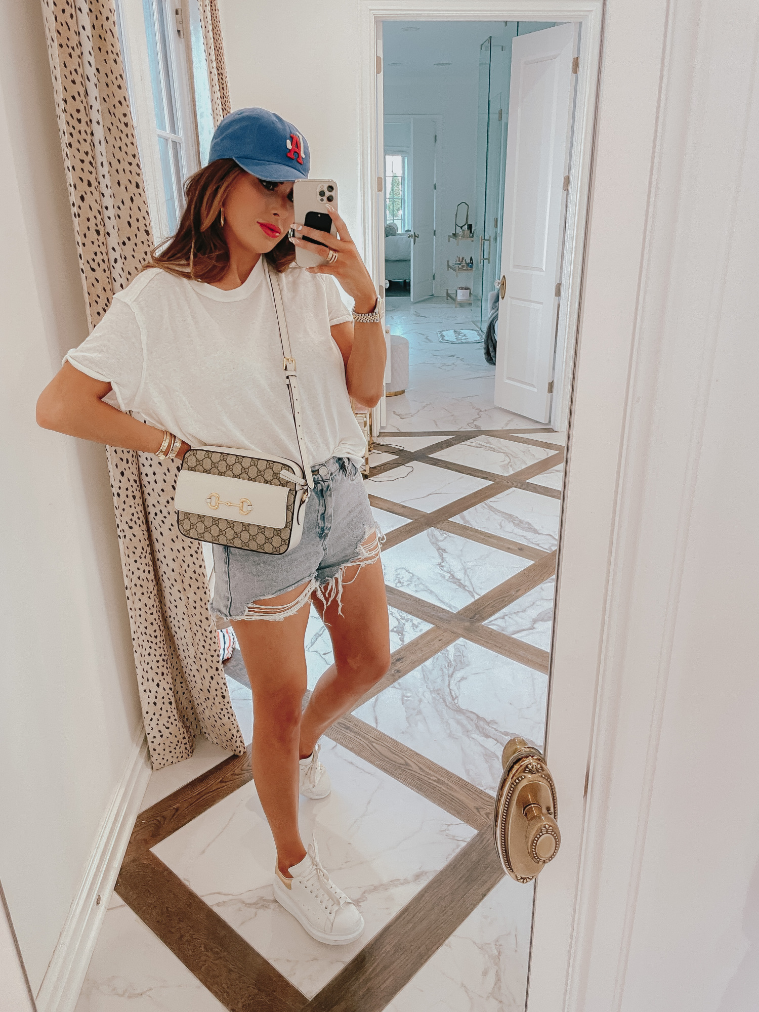 july 4 outfit inspiration 2021, pinterest july 4 outfit, gucci red lipstick, gucci 1955 horsebit crossbody, Emily gemma |  June Instagram Recap by popular US fashion blog, The Sweetest Thing: image of Emily Gemma wearing a blue baseball cap, white t-shirt, distressed shorts, and white sneakers. 