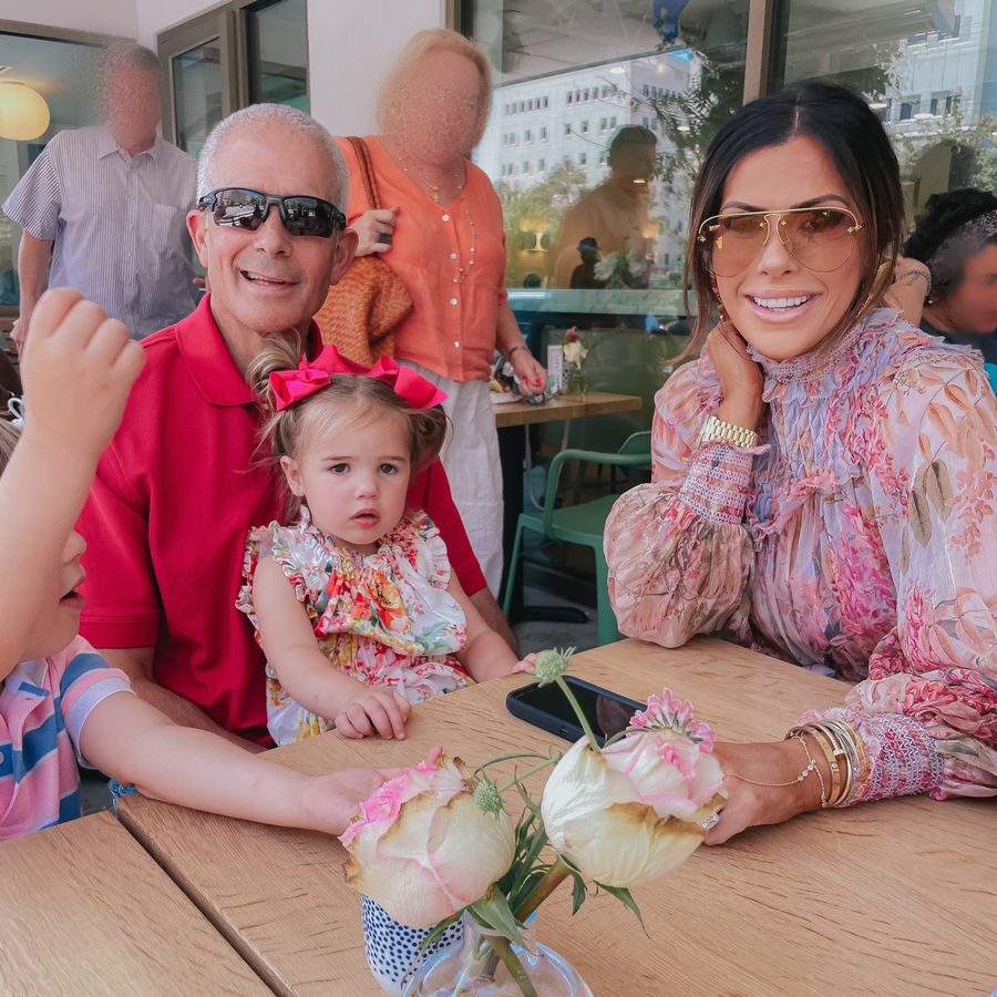 Zimmermann dress, floral dress, Emily ann gemma, Louis Vuitton sunglasses, Zimmermann kids romper, floral romper for little girls, bows for summer, Cartier bracelets, fathers day, summer 2021 | June Instagram Recap by popular US fashion blog, The Sweetest Thing: image of Emily Gemma sitter with her dad and daughter Sophie at a table. 