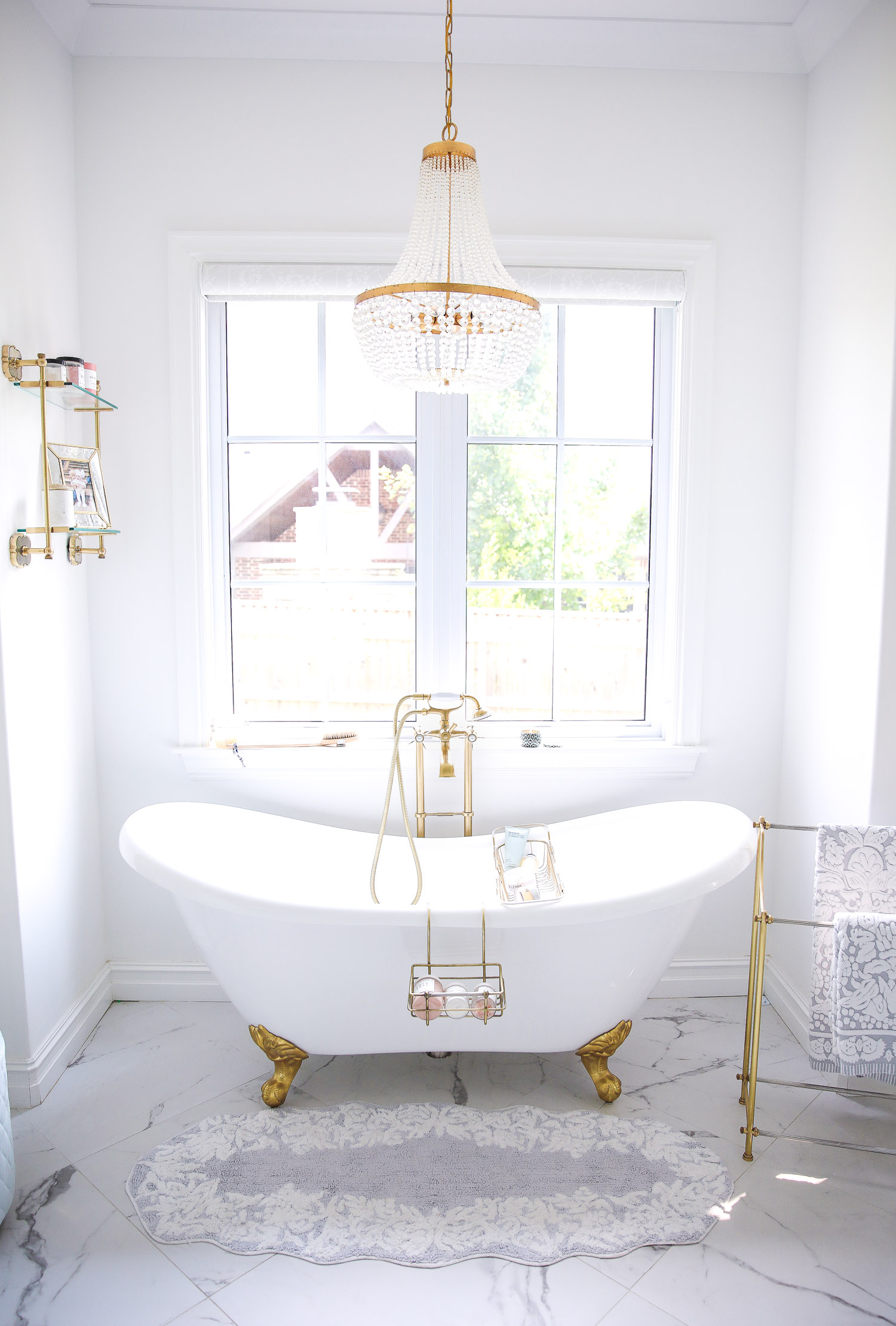 Emily gemma master bathroom, Nordstrom anniversary sale 2021 beauty must haves, anthropologie bathrom decor 2021, pinterest bathroom all white gold | Instagram Recap by popular US life and style blog, The Sweetest Thing: image of a white and gold clawfoot tub with a gold and crystal chandelier and gold towel rack. 