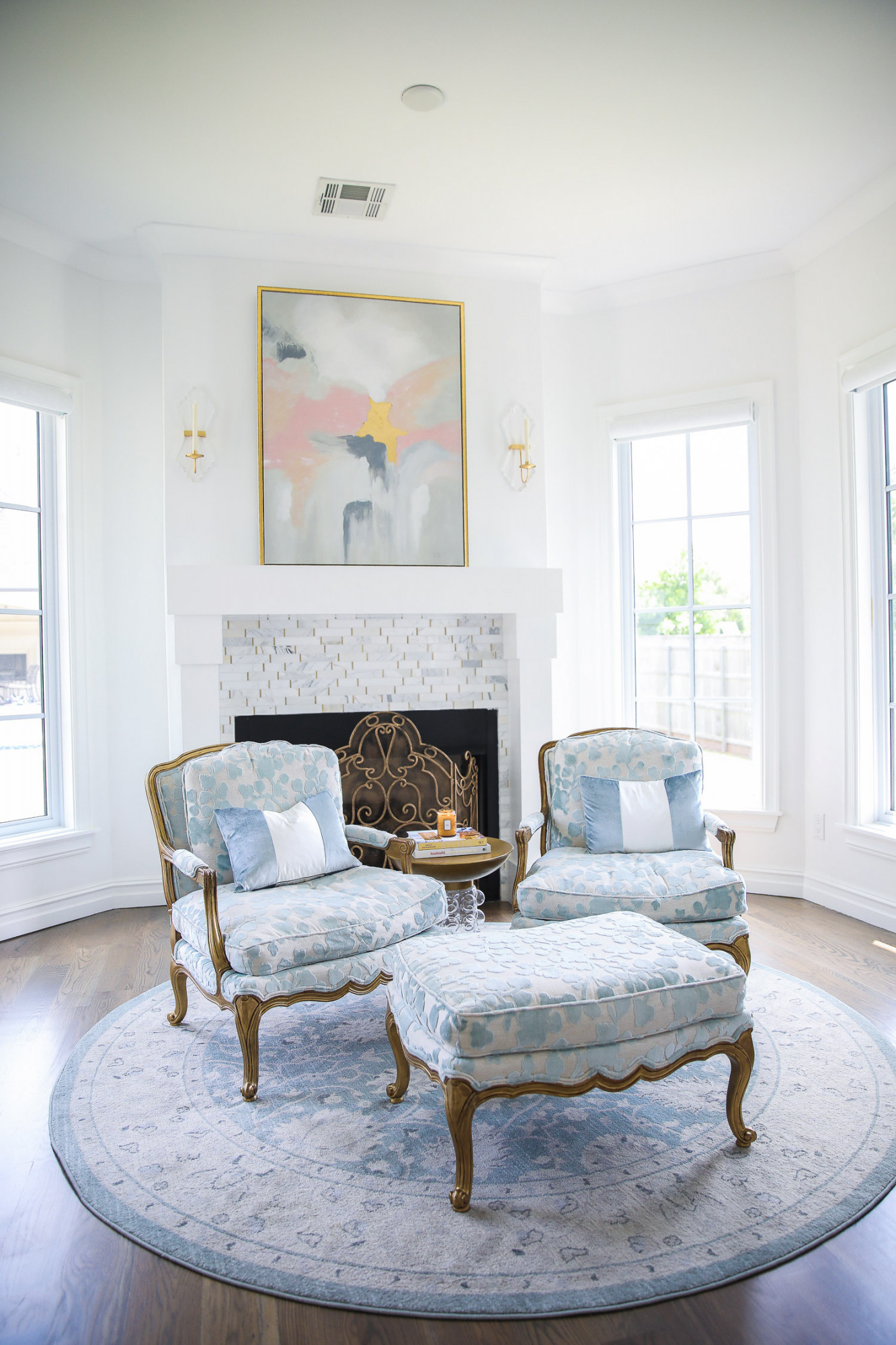 Instagram Recap by popular US life and style blog, The Sweetest Thing: image of a sitting room decorated with a pink, white, and grey abstract print and blue floral print sitting chairs and foot rest on a round blue and grey area rug. 