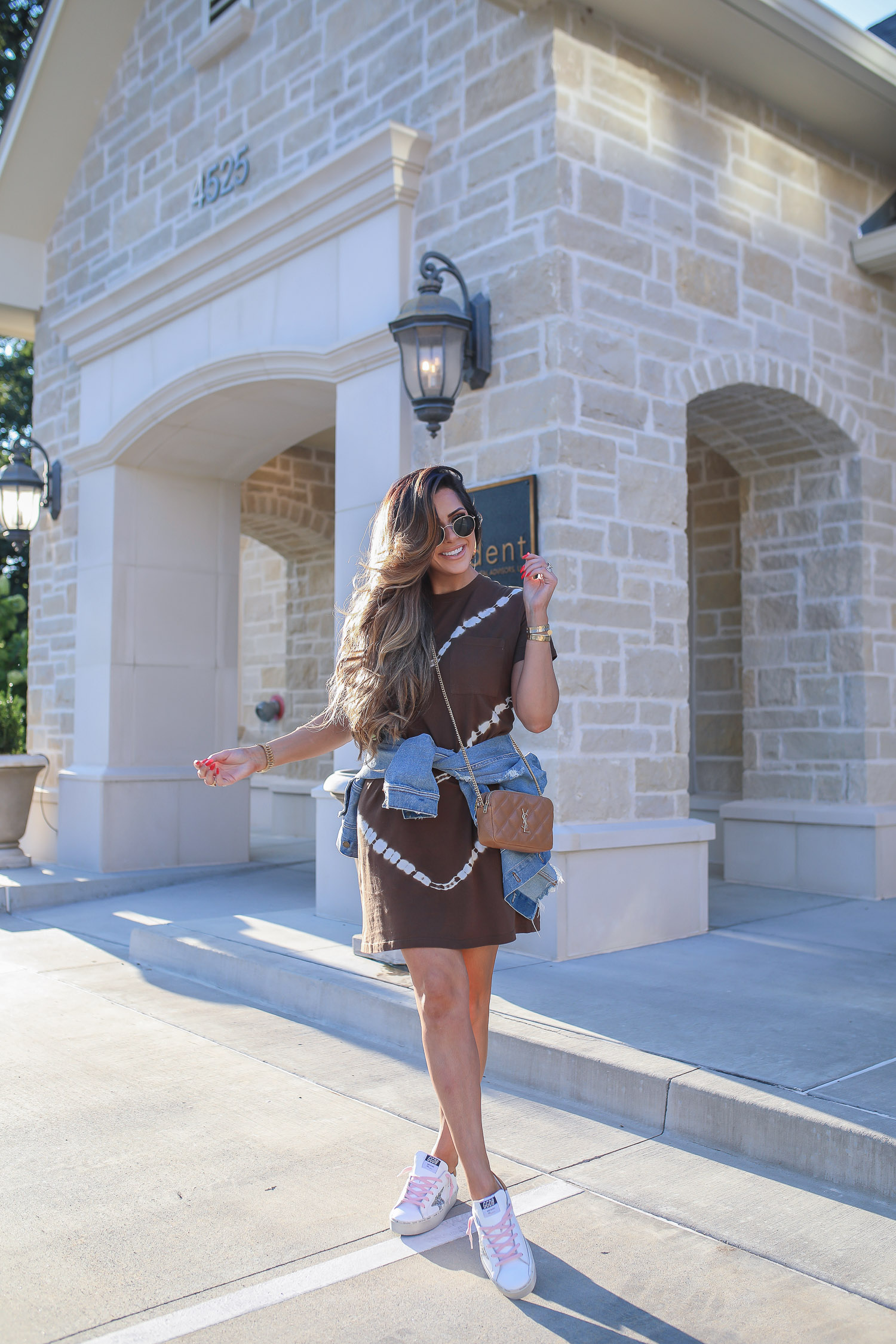 Fall Outfit by popular US fashion blog, The Sweetest Thing: image of Emily Gemma wearing. brown and white tie dye dress, white sneakers with pink laces, a denim jacket, and brown YSL crossbody bag. 