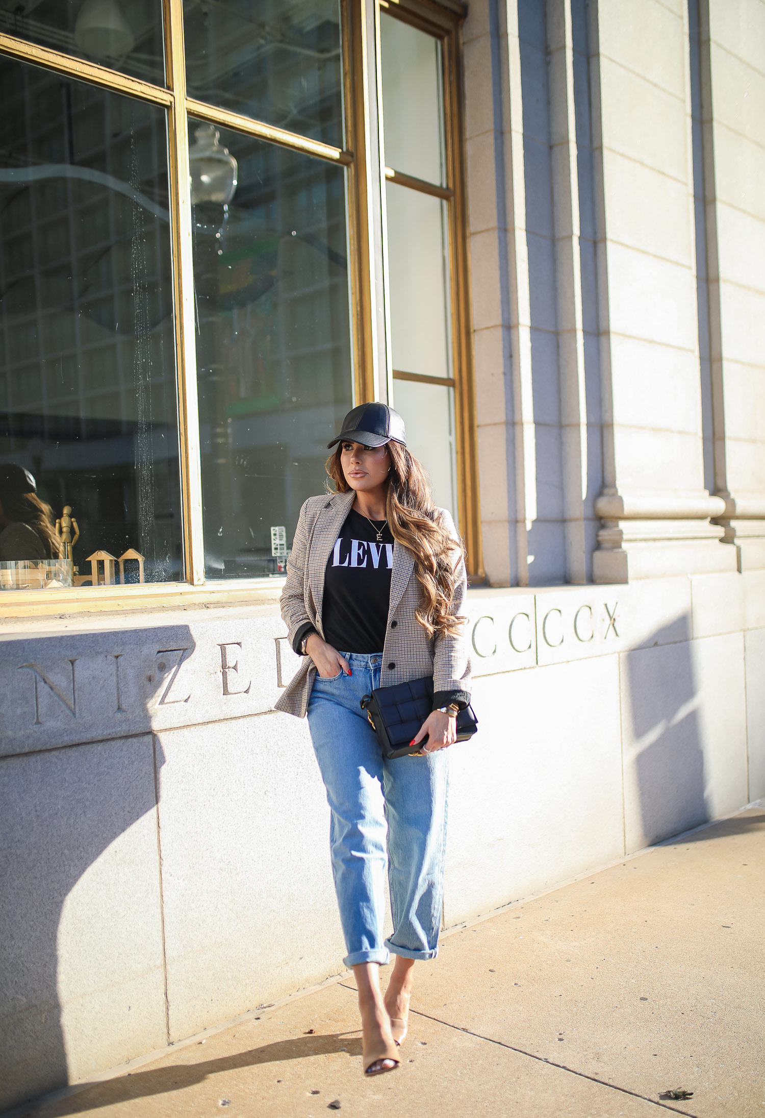 walmart fashion outfit ideas fall 2021, cute walmart outfit inspo fall, emiily gemma, tulsa fashion blogger, oversized plaid boyfriend blazer-10 | Fall Street Style by popular US fashion blog, The Sweetest Thing: image of Emily Gemma outside in a city and wearing black faux leather baseball hat, plaid jacket, leaves graphic t-shirt, rolled hem jeans, and tan stiletto heel sandals. 